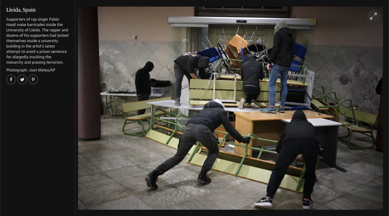 People removing chairs and tables from inside a university building in Lleida, Spain, as part of a protest or demonstration.