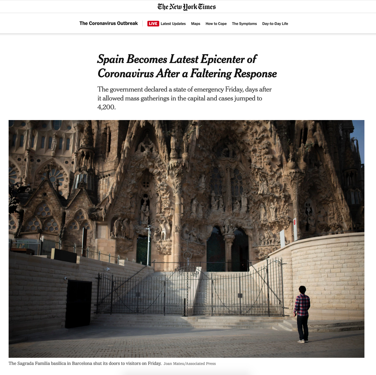 A young man standing outside the Sagrada Familia basilica in Barcelona, Spain, which has its doors closed to visitors.