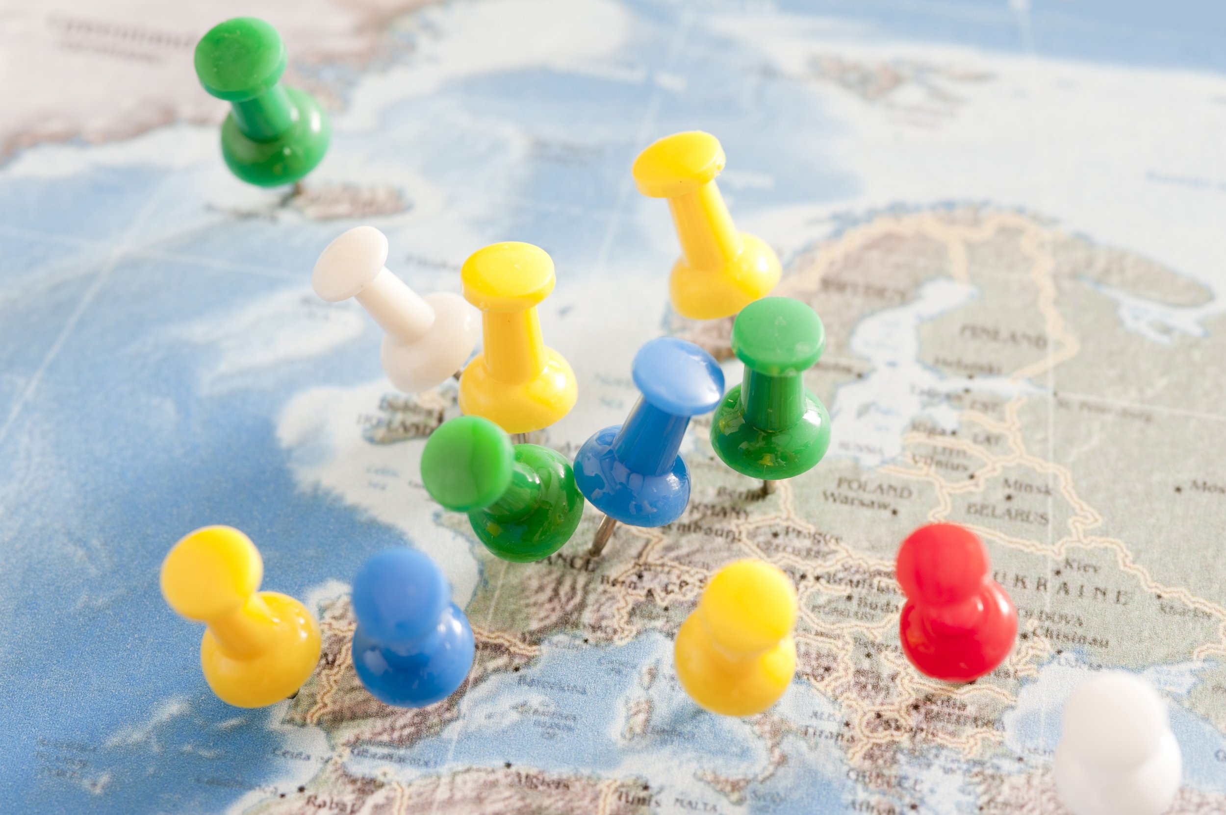 Colorful push pins arranged on a map of Europe and Asia.