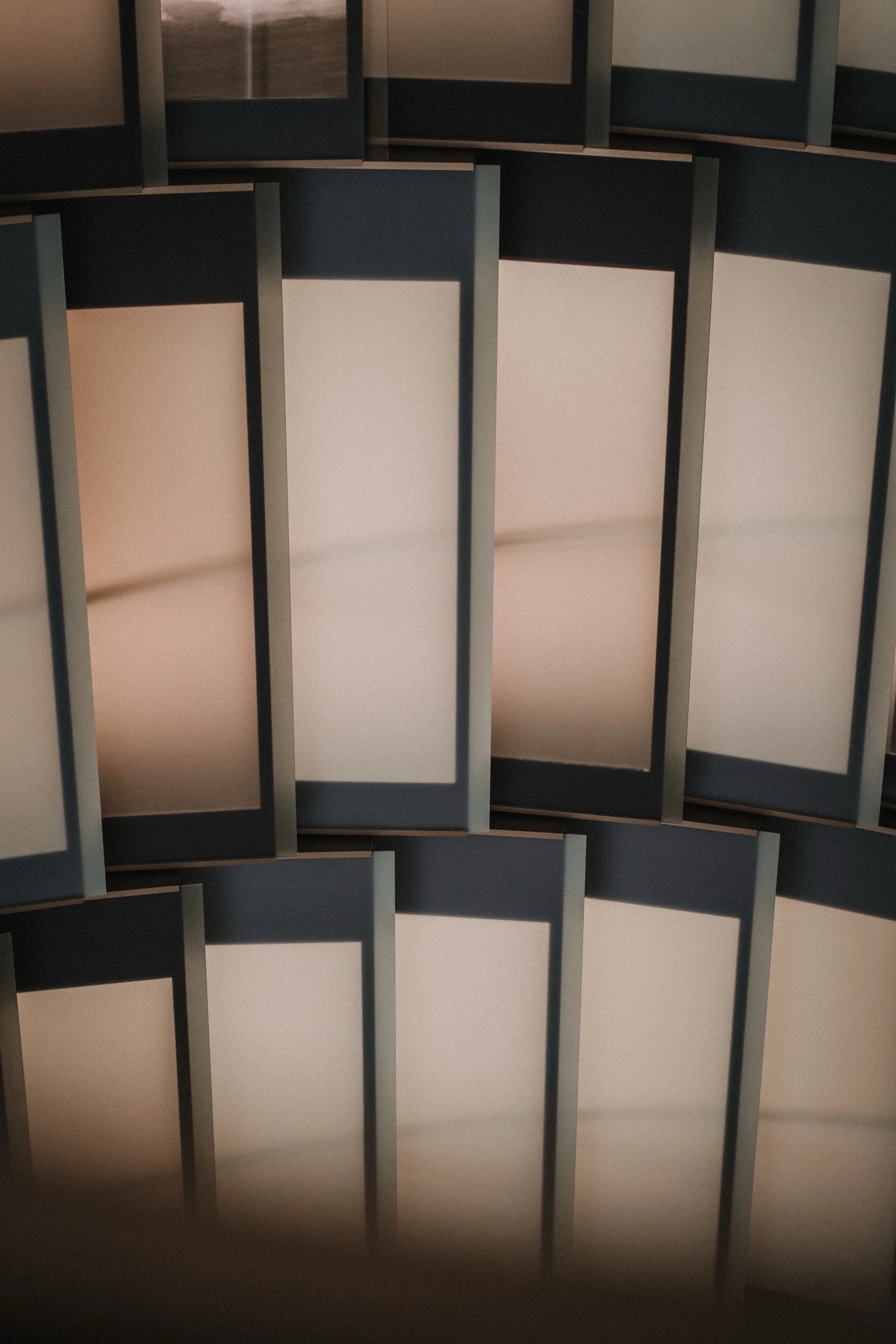 Mehrere leere, rechteckige Vitrinen mit dunklen Rahmen, die an einer Wand oder in einer Anordnung befestigt sind.