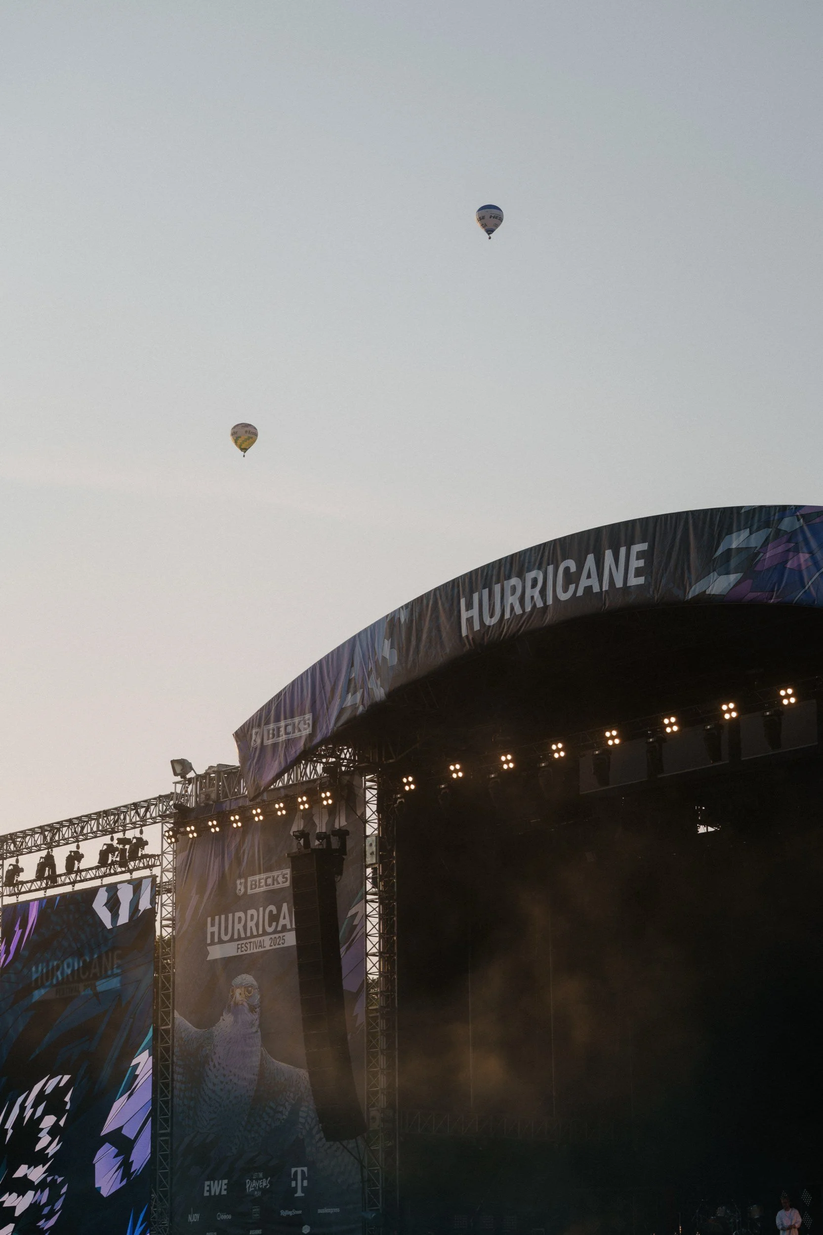 Luftballons über einer Festivalbühne mit dem Banner 'HURRICANE'.