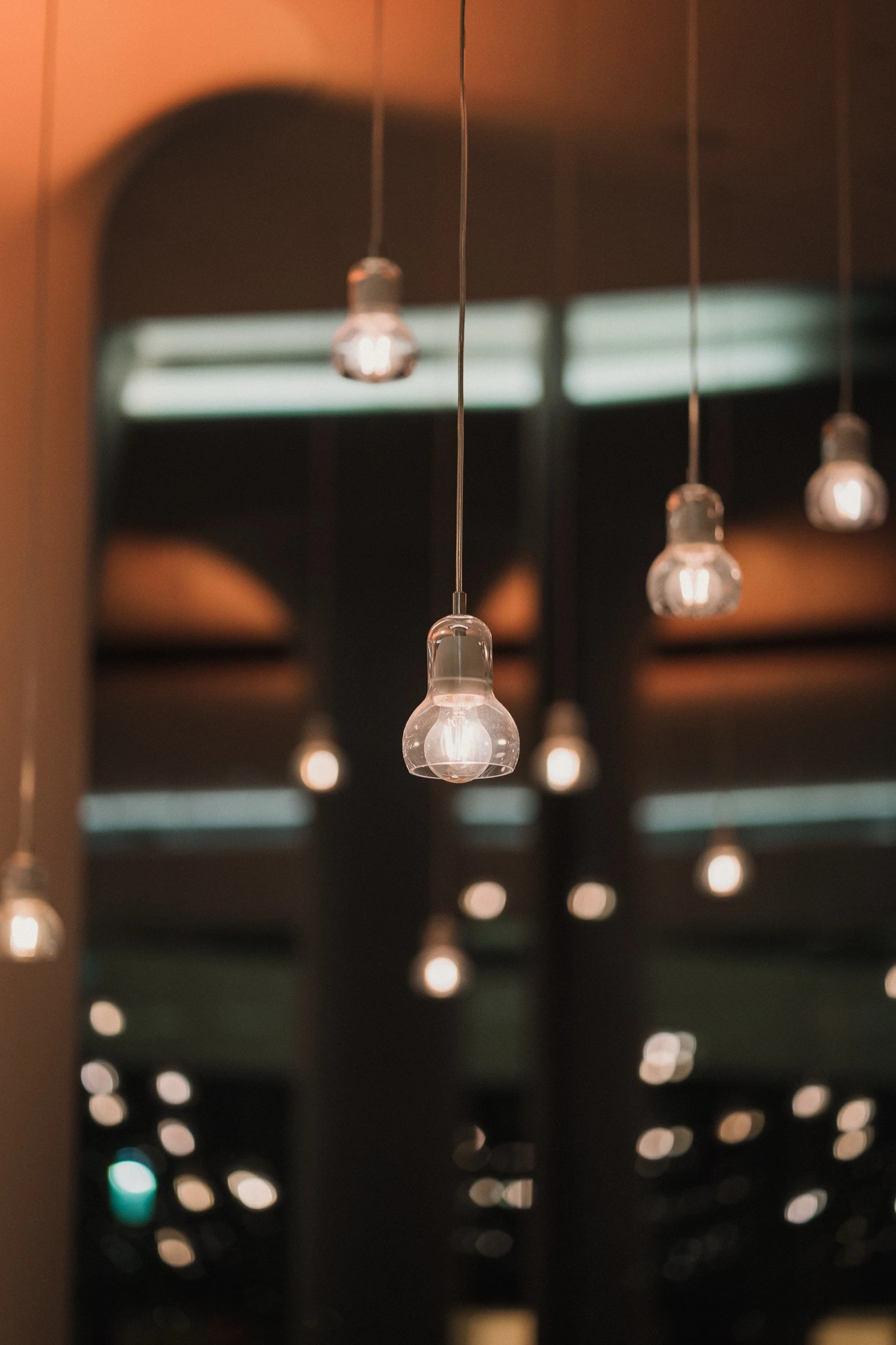 Hängende Glühbirnen in einem modernen Innenraum, unscharfer Hintergrund.