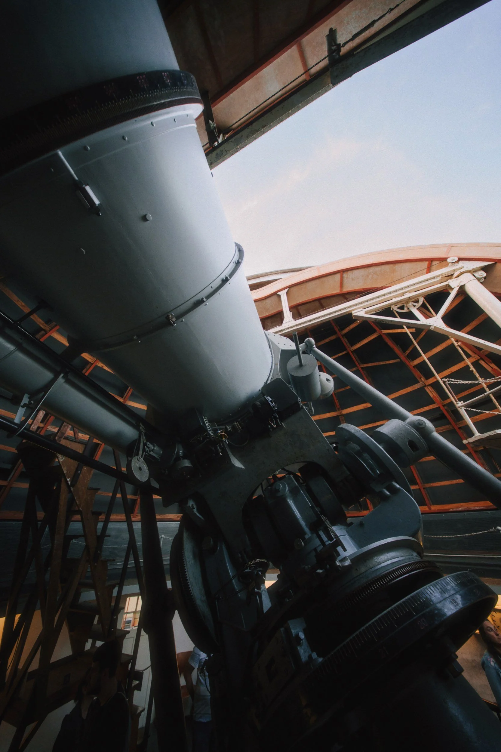 Großer Teleskop im Inneren einer Kuppel, Blick nach oben auf den Himmel durch die Kuppelöffnung.