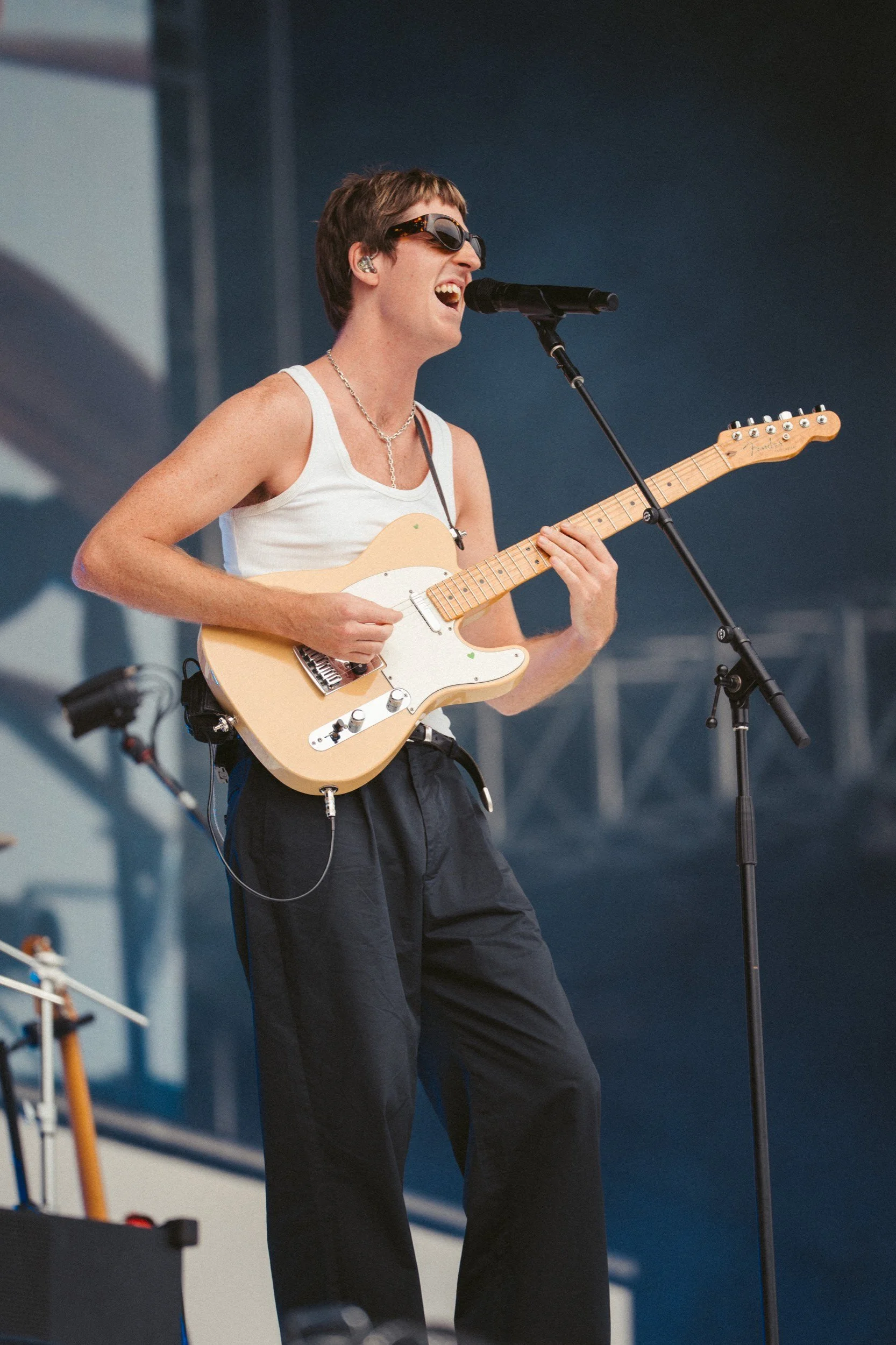 Der Sänger spielt Gitarre und singt bei einem Live-Auftritt auf einer Bühne.