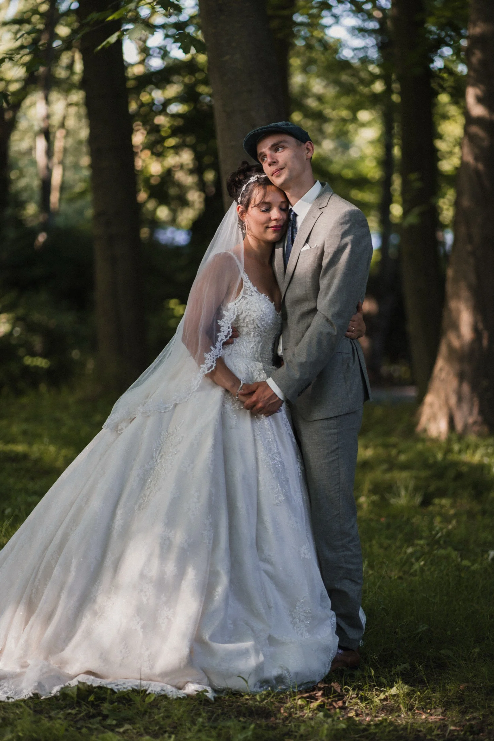 Braut und Bräutigam umarmend im Wald bei Sonnenlicht.