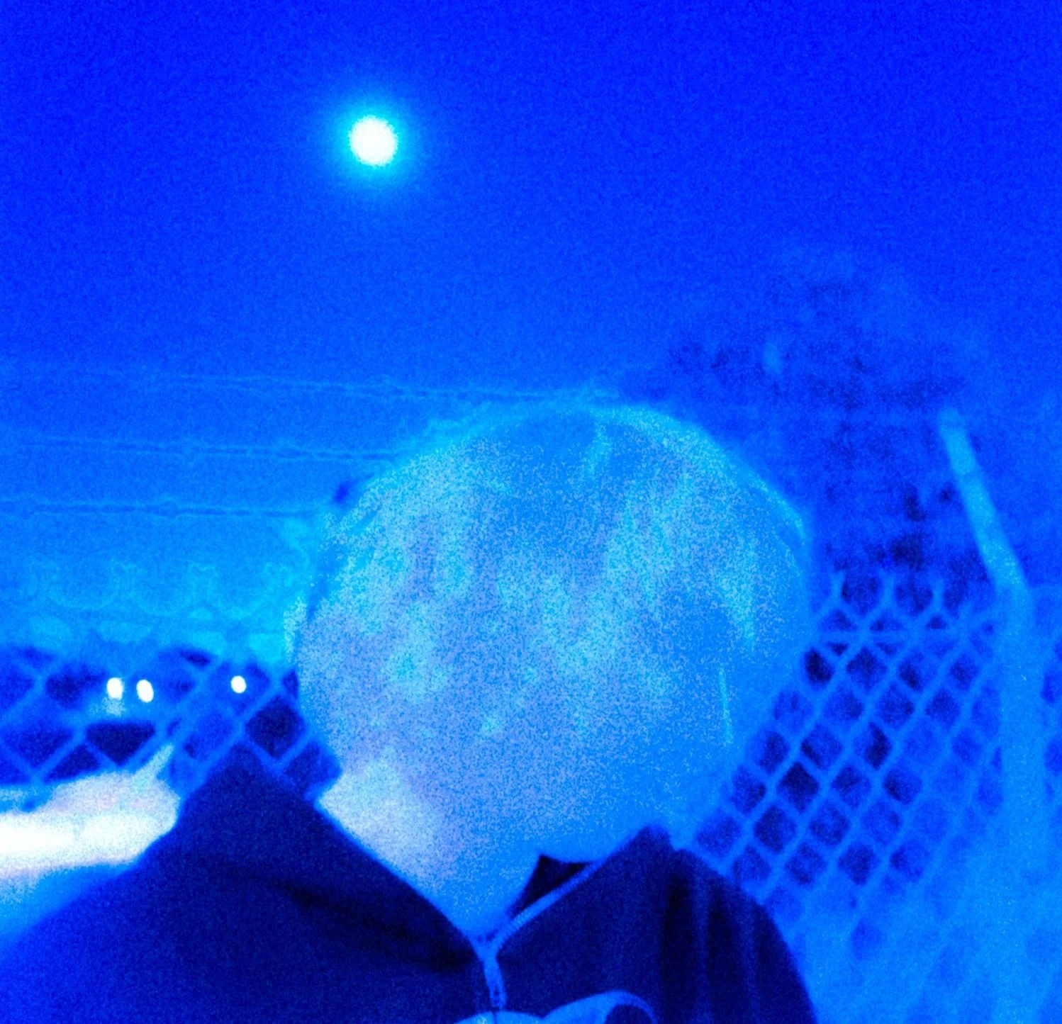 A person holding a white balloon with the moon visible in the night sky.