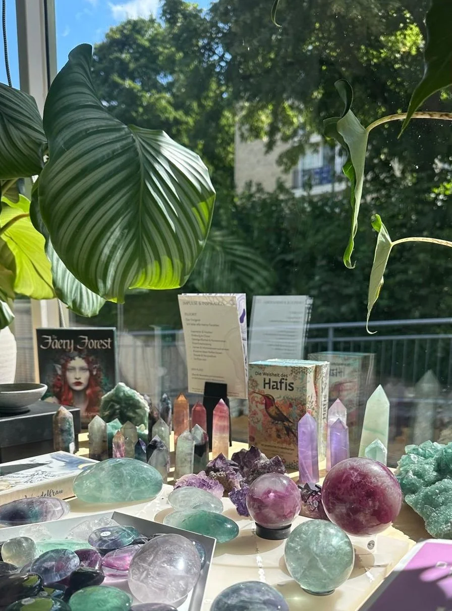 Stillleben aus Kristallen, Büchern und Duftprodukten auf Tisch arrangiert, inspirierende Auswahl im Concept Store Prana Station Hamburg.