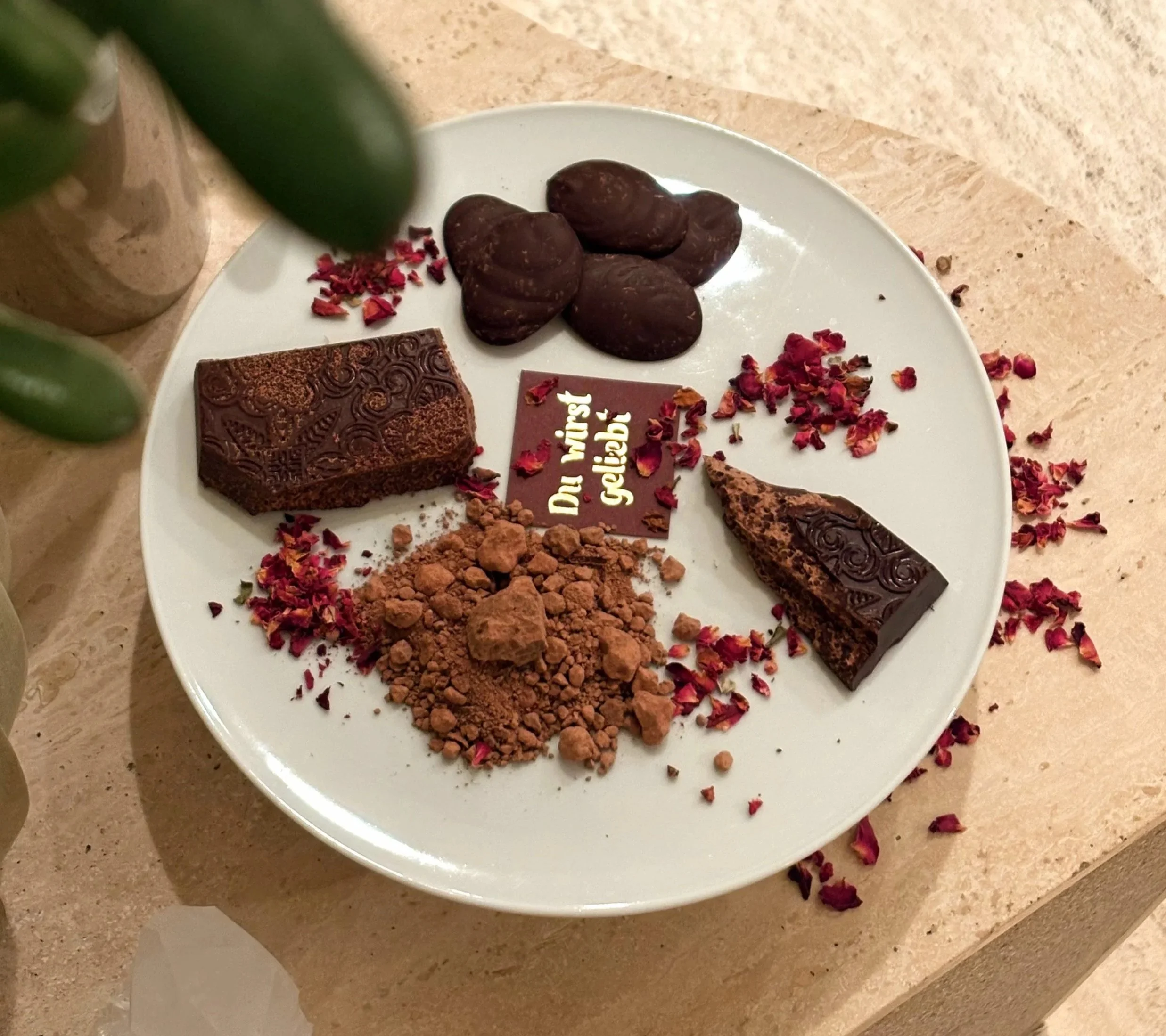 Ritualcacao in verschiedenen Formen auf Teller arrangiert, Kakaostücke und Pulver als bewusste Alternative zu Kaffee.
