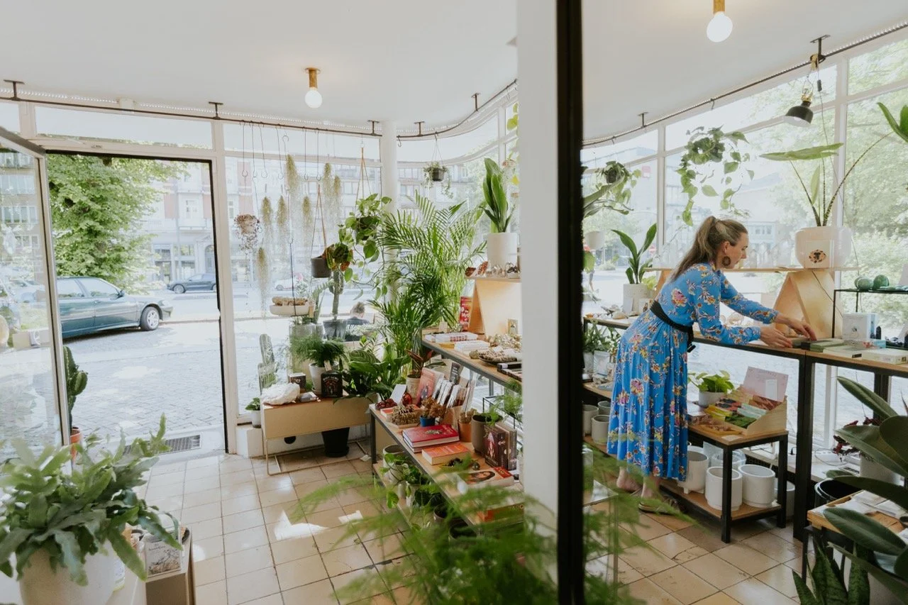 Innenansicht des Prana Station Stores in Hamburg mit Pflanzen, Kristallen und Naturprodukten, lichtdurchfluteter Raum mit einladender Atmosphäre.