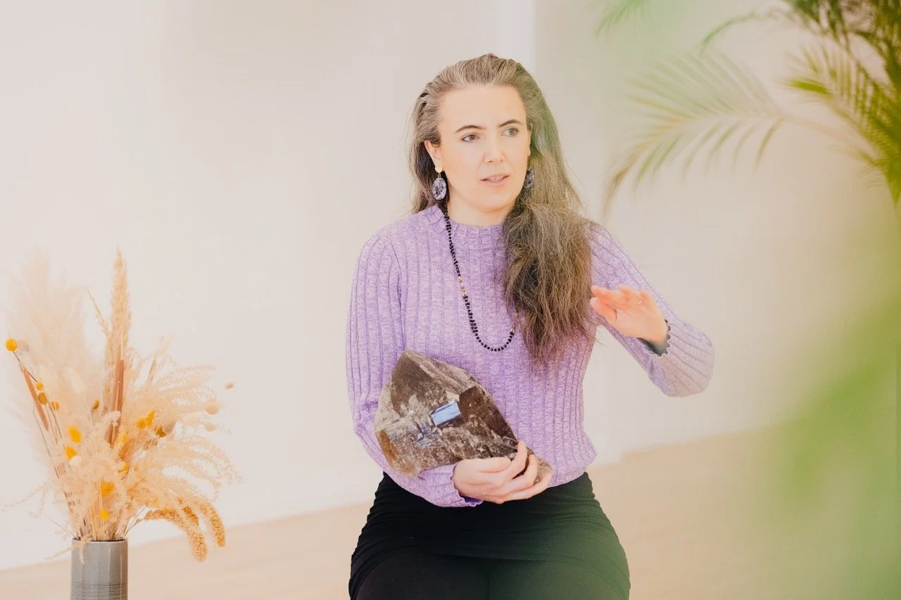 Hanna Lipp hält einen großen Rauchquarz-Kristall während eines Community-Events, ruhige Szene in hellem Raum, Verbindung von Achtsamkeit, Austausch und Spiritualität bei Prana Station Hamburg.