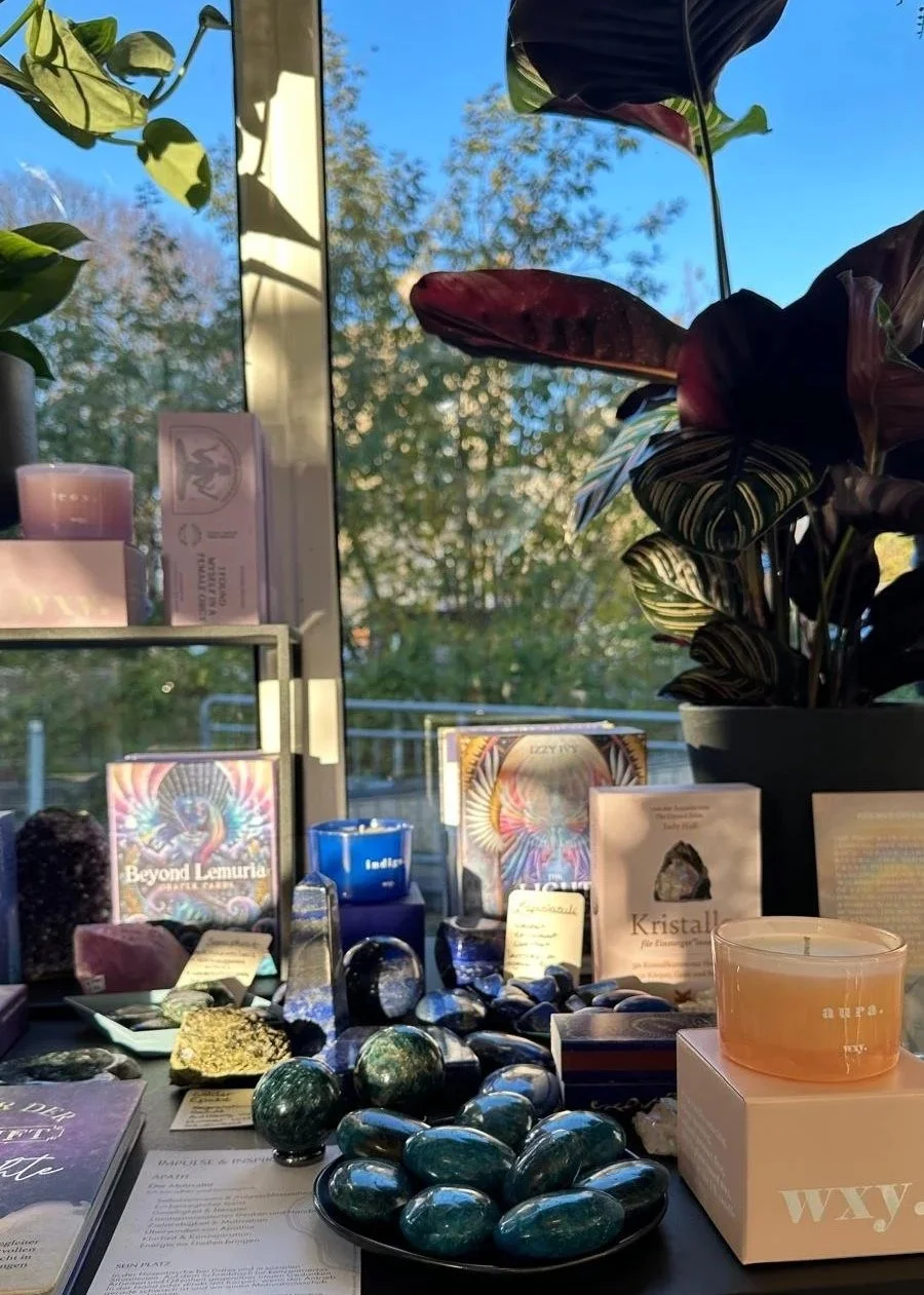 Tisch mit Kristallen, Büchern und Pflanzen dekoriert, harmonische Präsentation im Prana Station Store Hamburg.