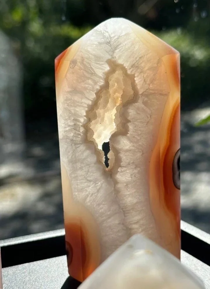 Achat-Geode in Stelenform mit natürlicher Öffnung, warmes Licht betont die feinen Strukturen des Steins.