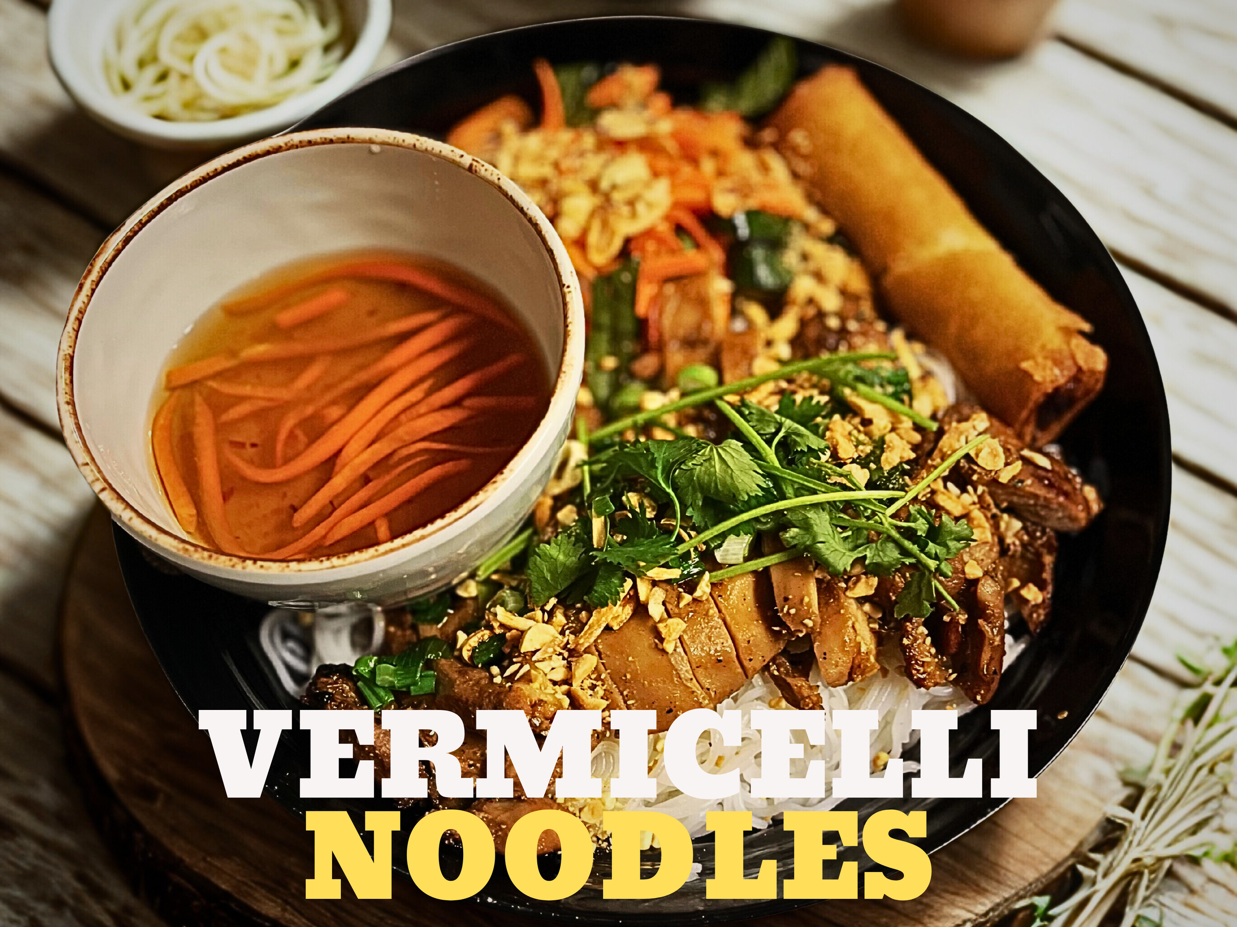 A bowl of Vermicelli noodles topped with grilled meat, vegetables, and herbs, with a side of broth with vermicelli noodles visible inside.