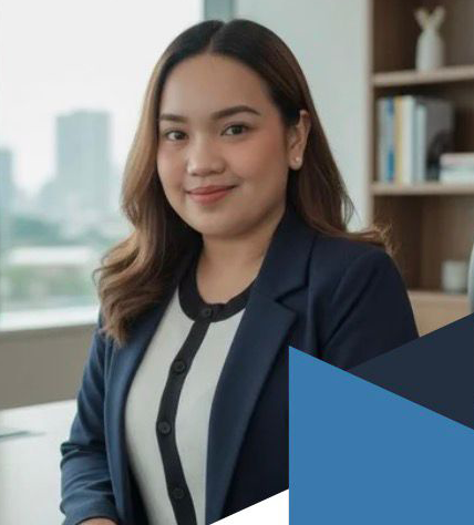 A woman with long brown hair, wearing a navy blazer and a white blouse, standing in an office with a window and bookshelf in the background.
