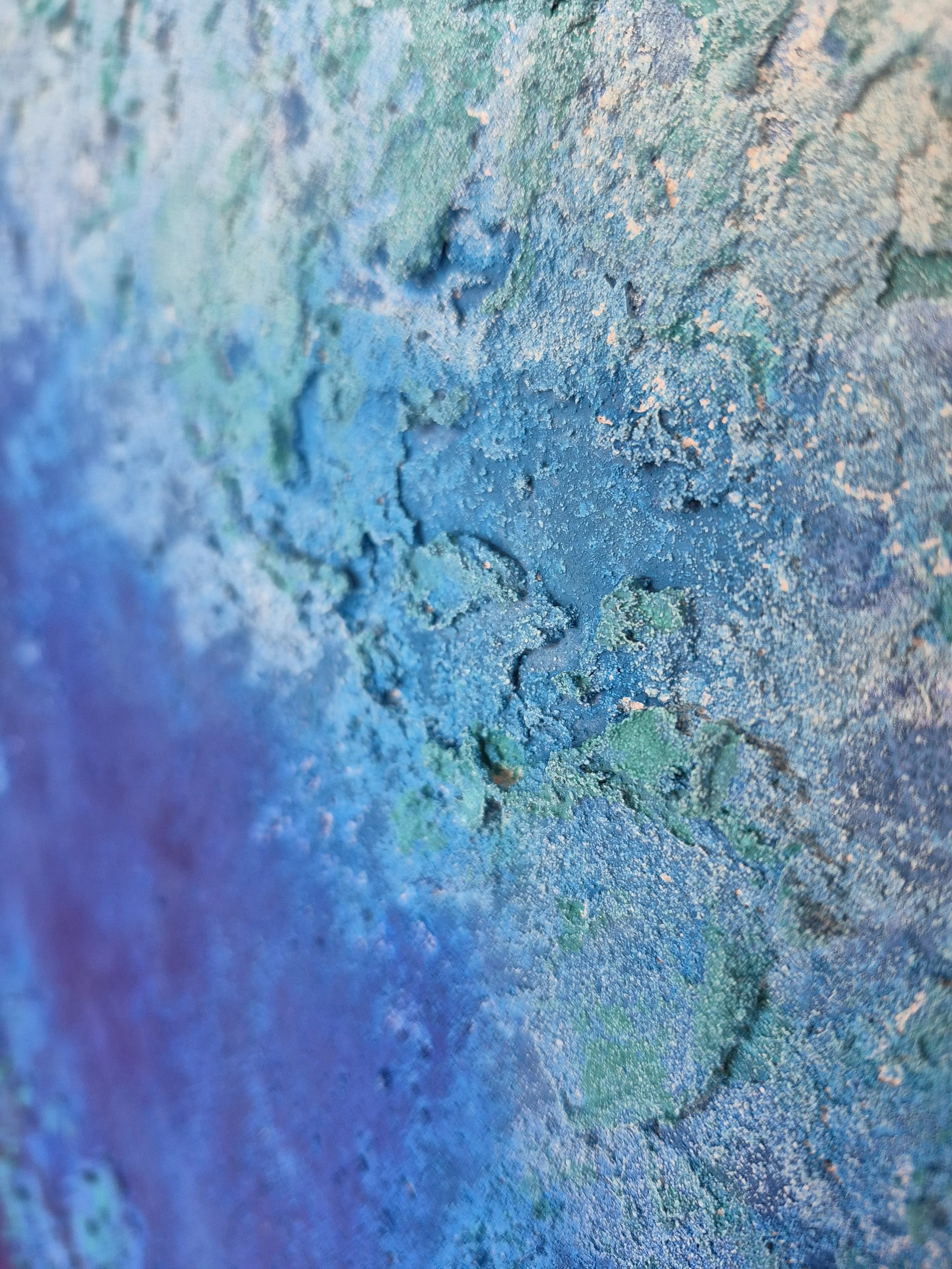 ​Stort blåt abstrakt maleri (90x120 cm) med nuancer af turkis, navy og hvid monteret i en moderne lys stue. Moderne dansk kunst til væggen.