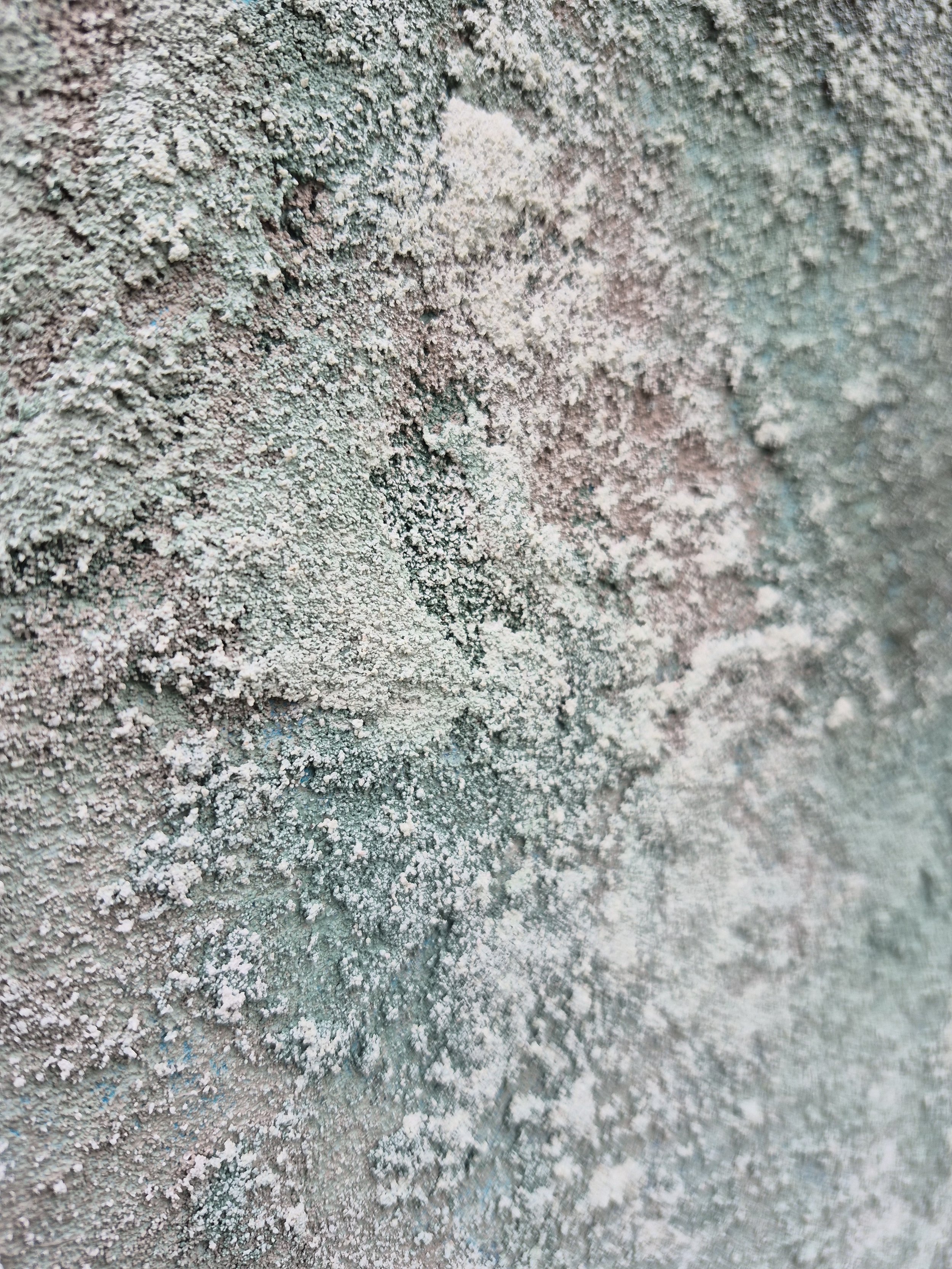 Et meget stort abstrakt maleri med kraftig struktur i hvirvlende lag af teal, søgrøn, grå, kulpigment og hvid. Maleriet hænger på en lys væg i en modern spiseplads over en skænk i lyst træ.