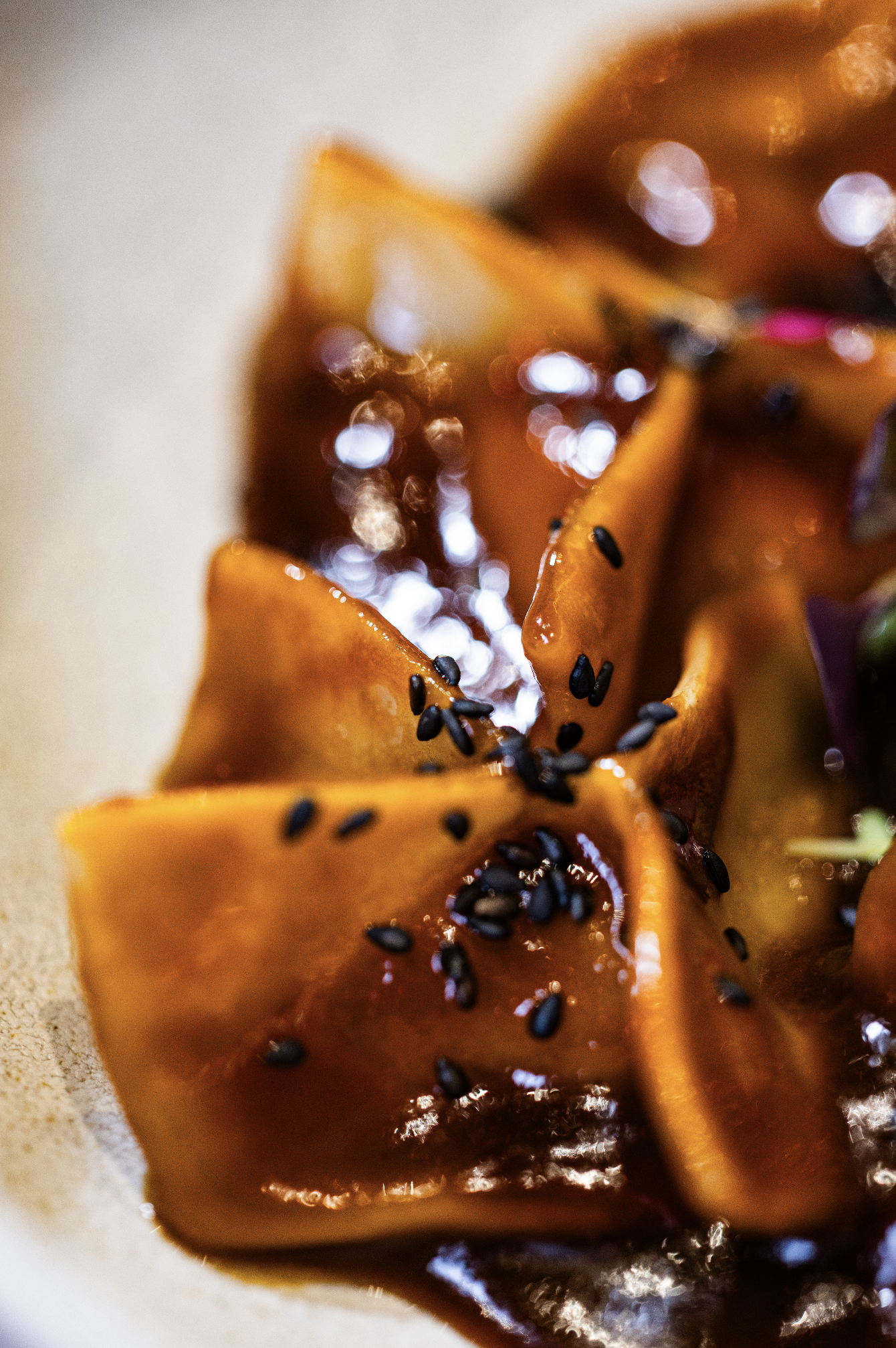 Close-up of roasted or glazed sliced carrots garnished with black sesame seeds.
