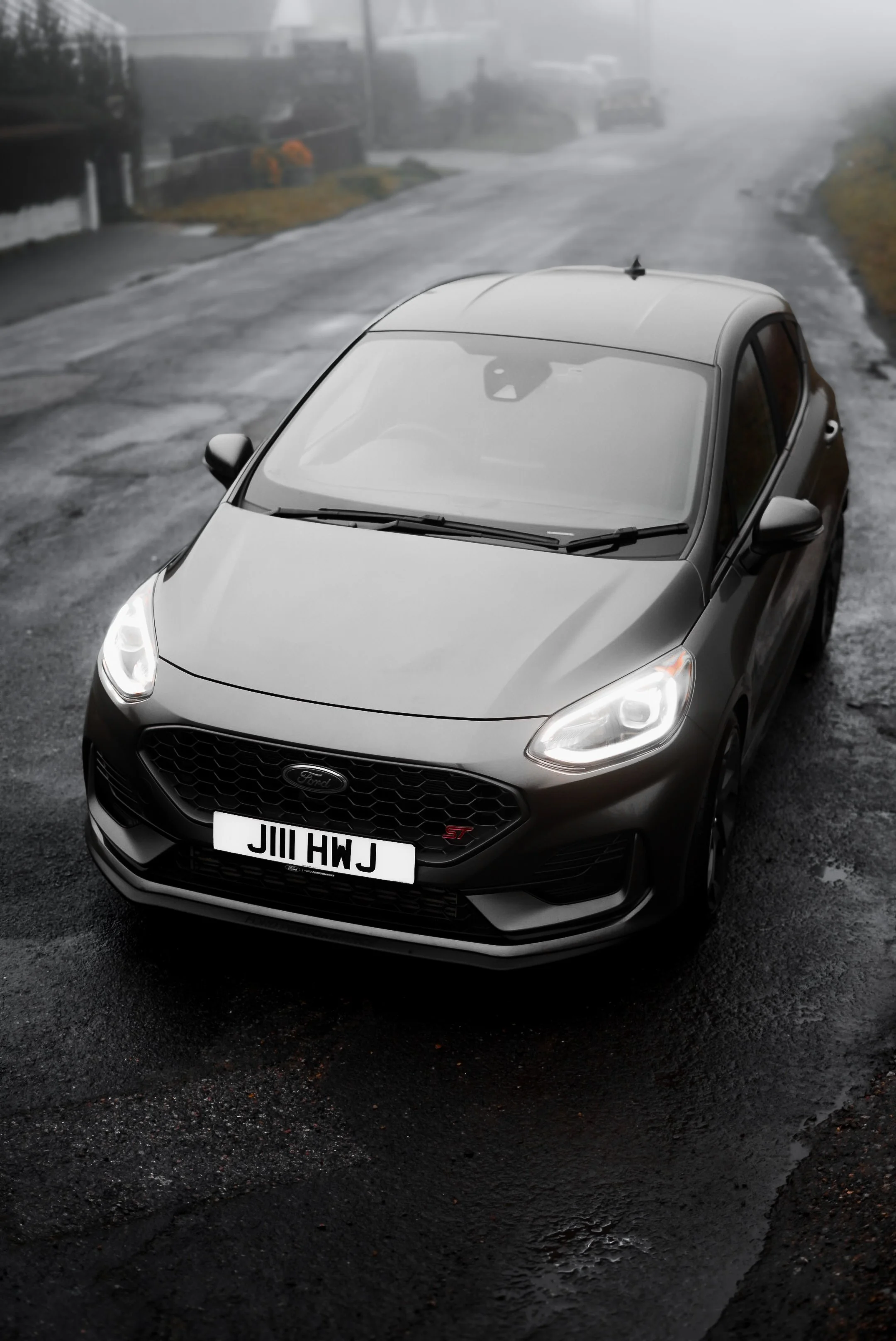 Gray Ford Fiesta ST parked on wet street on foggy day