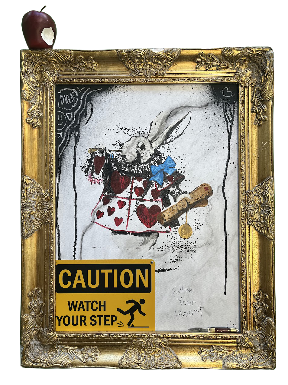 A framed graffiti art depicting a white rabbit with a blue bow tie, wearing a dress with red hearts and black accents, holding a scroll. An apple with a bite mark is placed on top of the gold ornate frame. A yellow caution sign on the bottom left warns, 'Watch Your Step,' with an icon of a person slipping. The background with streaks of colorful lines at the top.