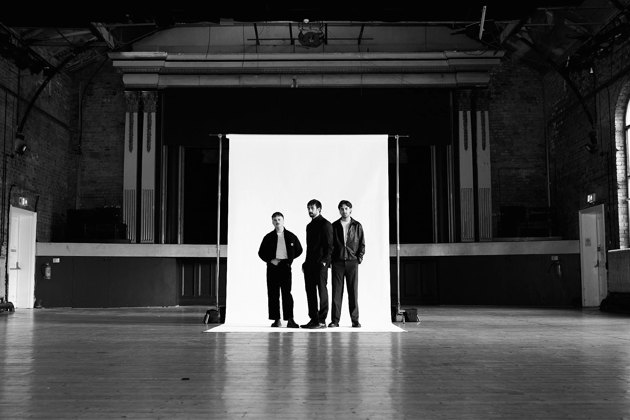 People Laughing band photo taken in an industrial venue with a white backdrop.