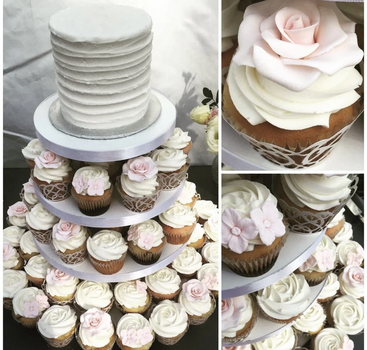 A layered wedding cake on a three-tiered stand, decorated with cupcakes featuring white frosting and pink frosting flowers.