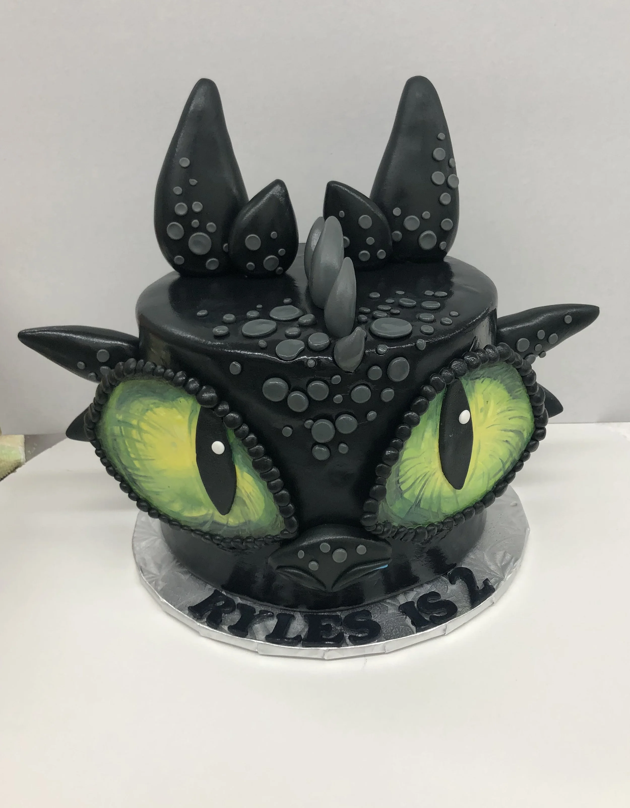 A cake decorated to look like Toothless from How To Train Your Dragon.