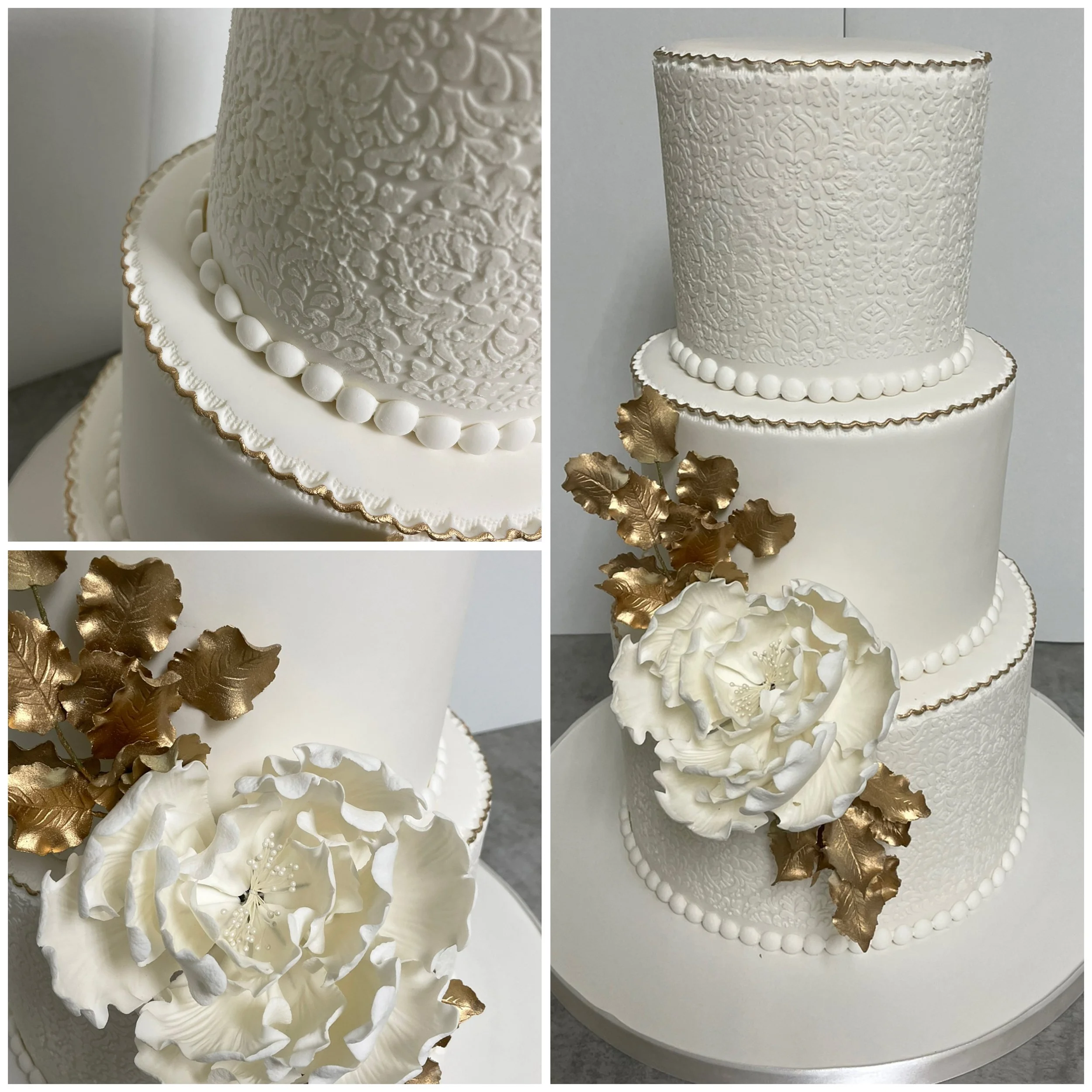 Three-tier white wedding cake with textured and smooth fondant, gold accents, floral decorations, and intricate patterns.