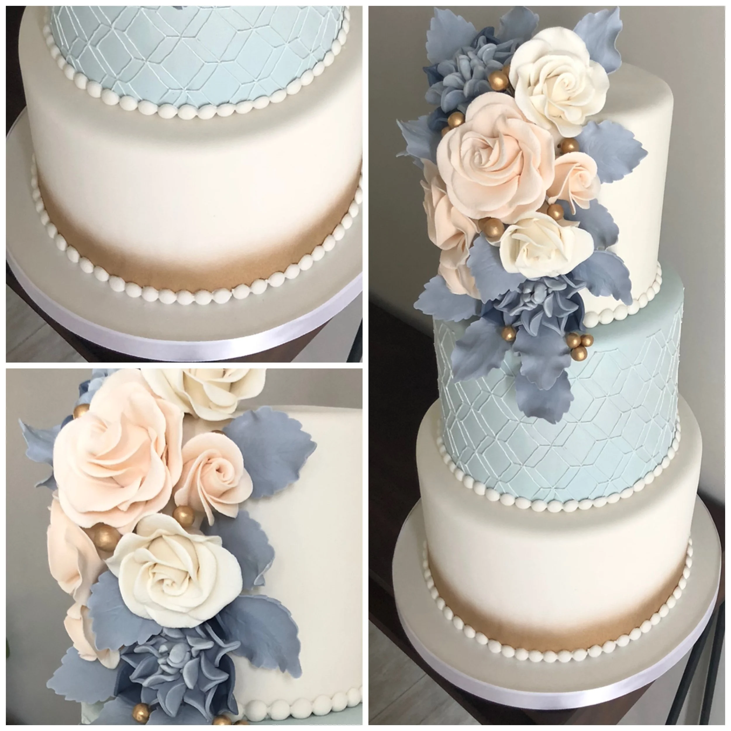 Two-tier wedding cake with white and light blue design, decorated with white and blush pink roses, blue-gray leaves, and gold accents, topped with pearl-like decorations.
