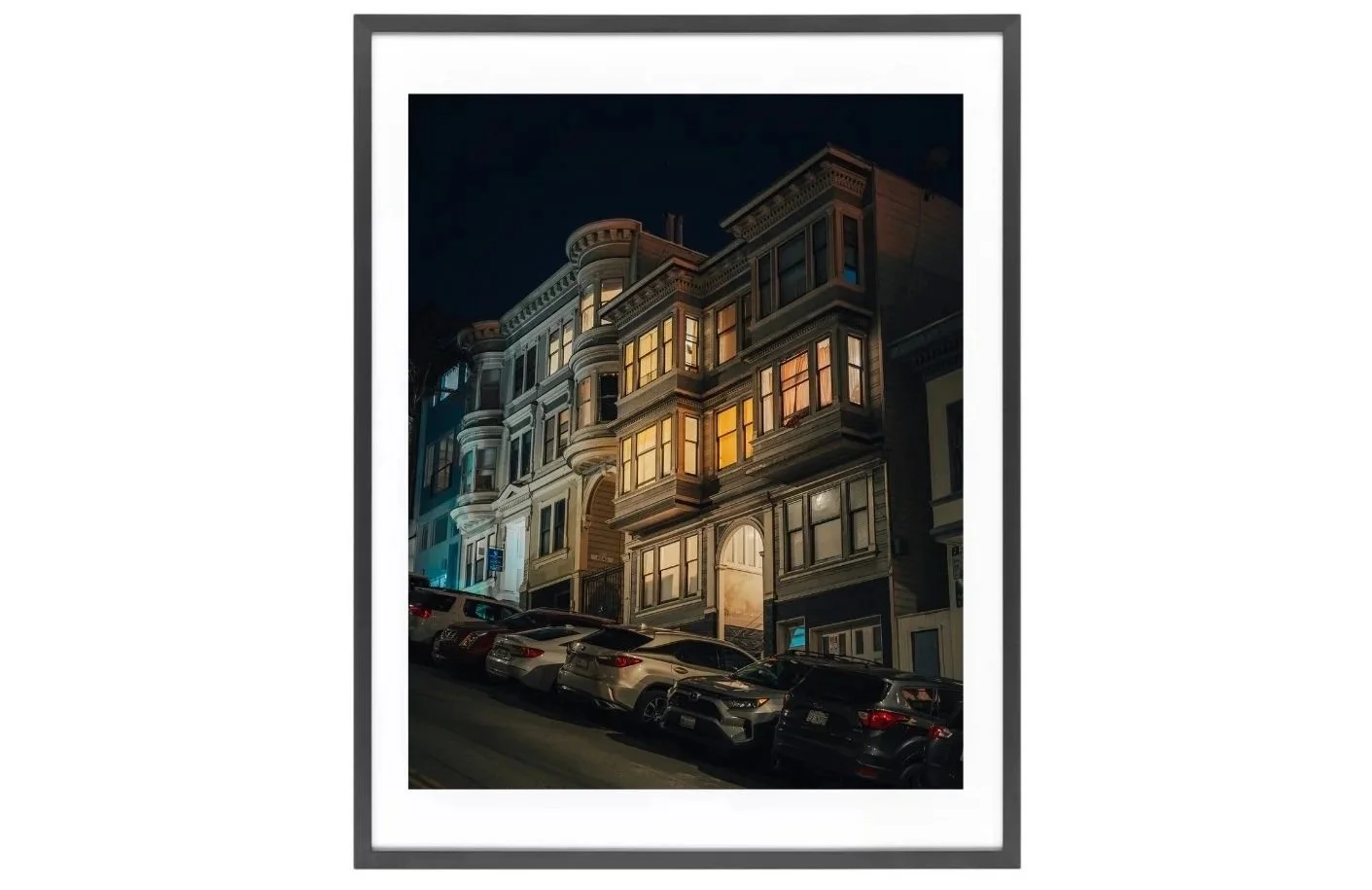 Night view of North Beach houses lit from windows, seen from the bottom of the hill.