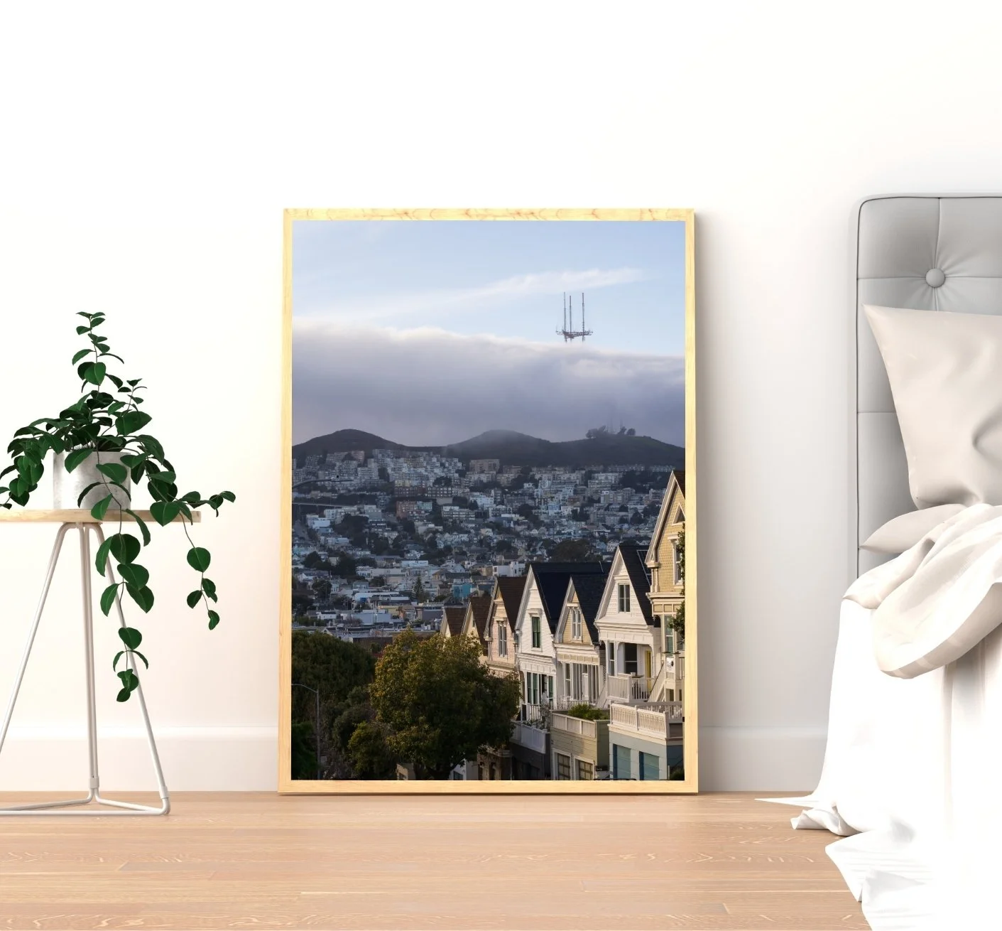 San Francisco Victorian houses lit by the last sunlight in the foreground, with fog rolling over Twin Peaks and Sutro Tower peeking above the mist in the background.