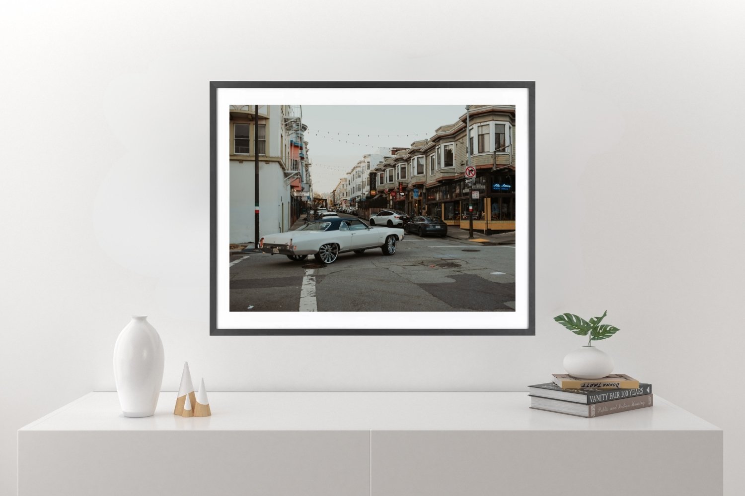 Vintage car driving up Grant Avenue in San Francisco with hillside houses on the right, city street scene.