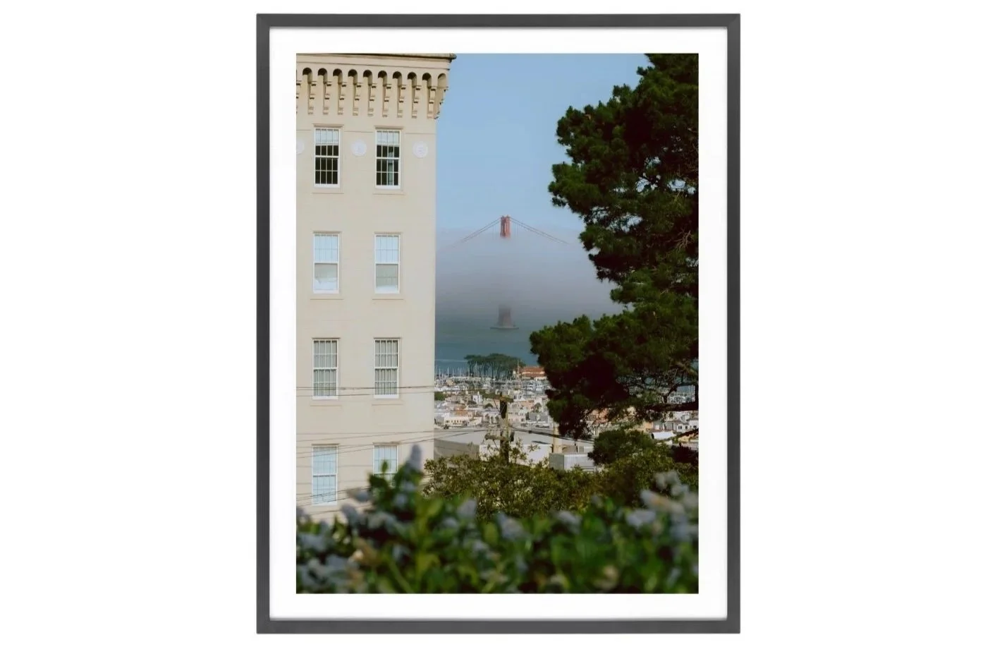 Golden Gate Bridge in fog between buildings