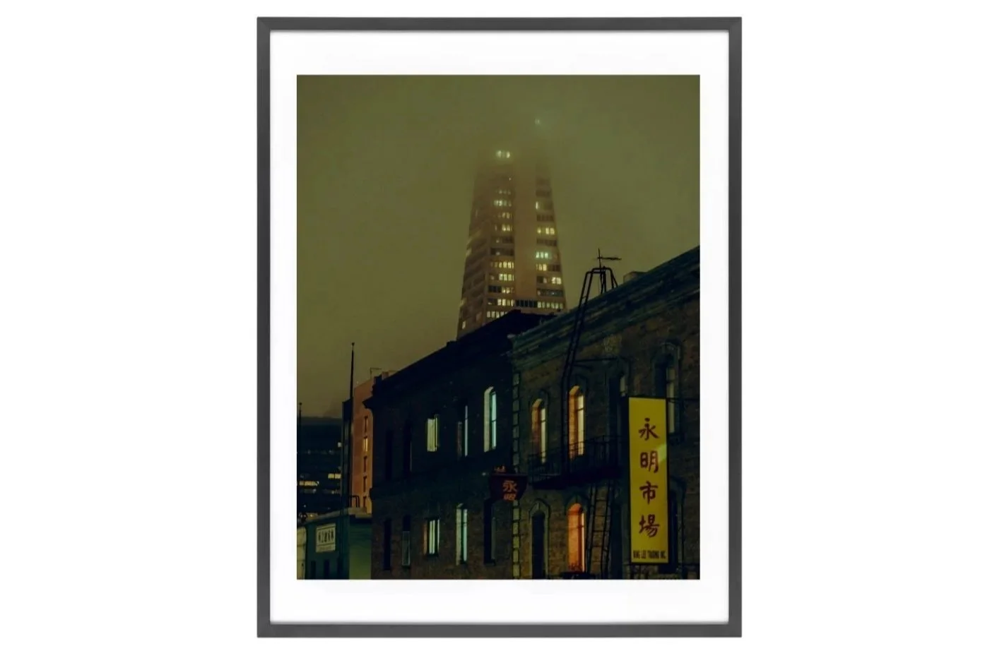 Foggy night in Chinatown, San Francisco, with orange-lit fog, old brick building, and Transamerica Pyramid partly obscured.