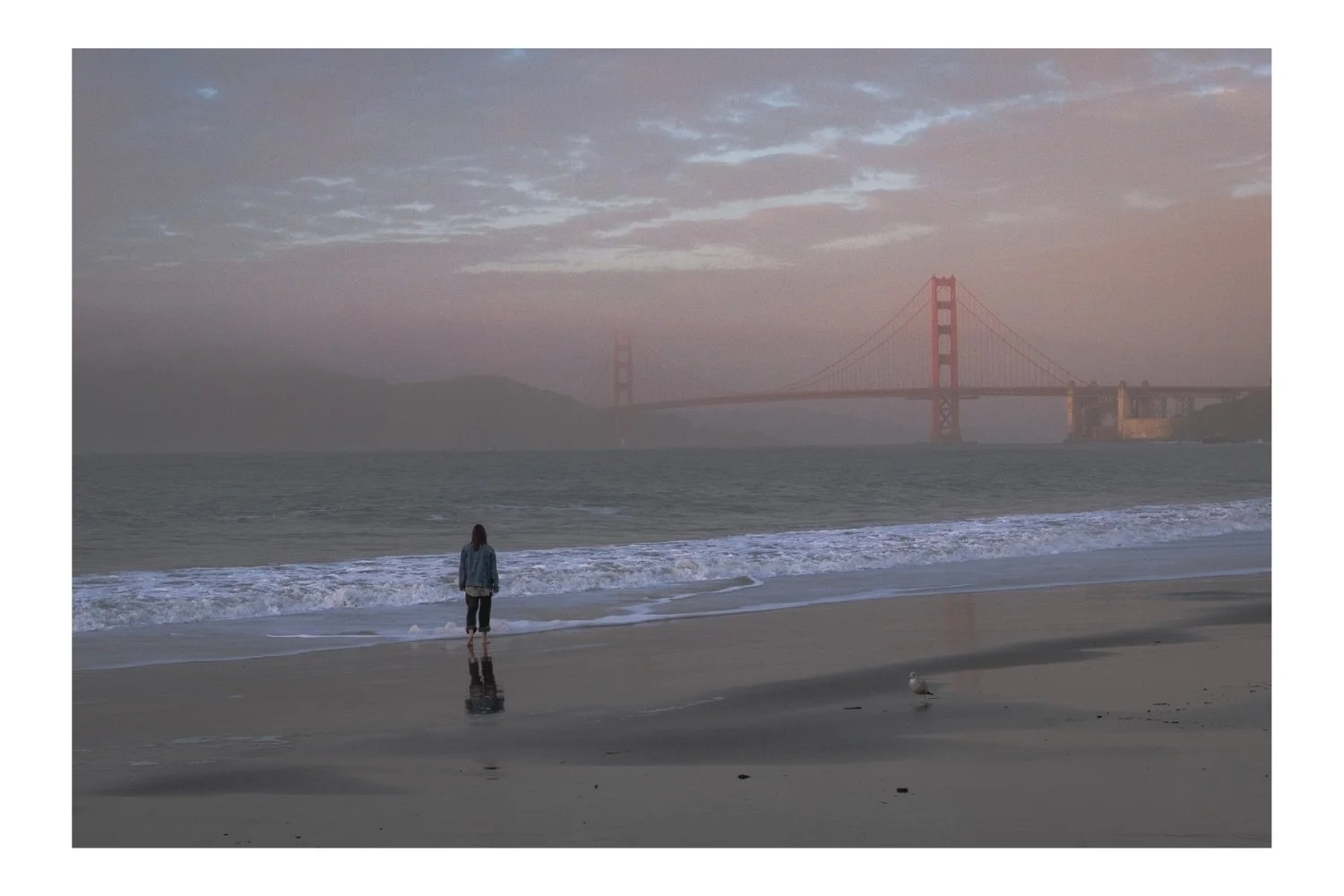China Beach sunset with the Golden Gate Bridge in the background and a girl in the foreground
