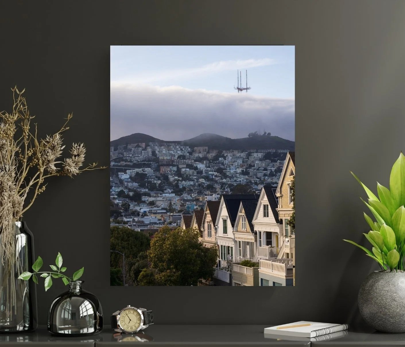 San Francisco Victorian houses lit by the last sunlight in the foreground, with fog rolling over Twin Peaks and Sutro Tower peeking above the mist in the background.