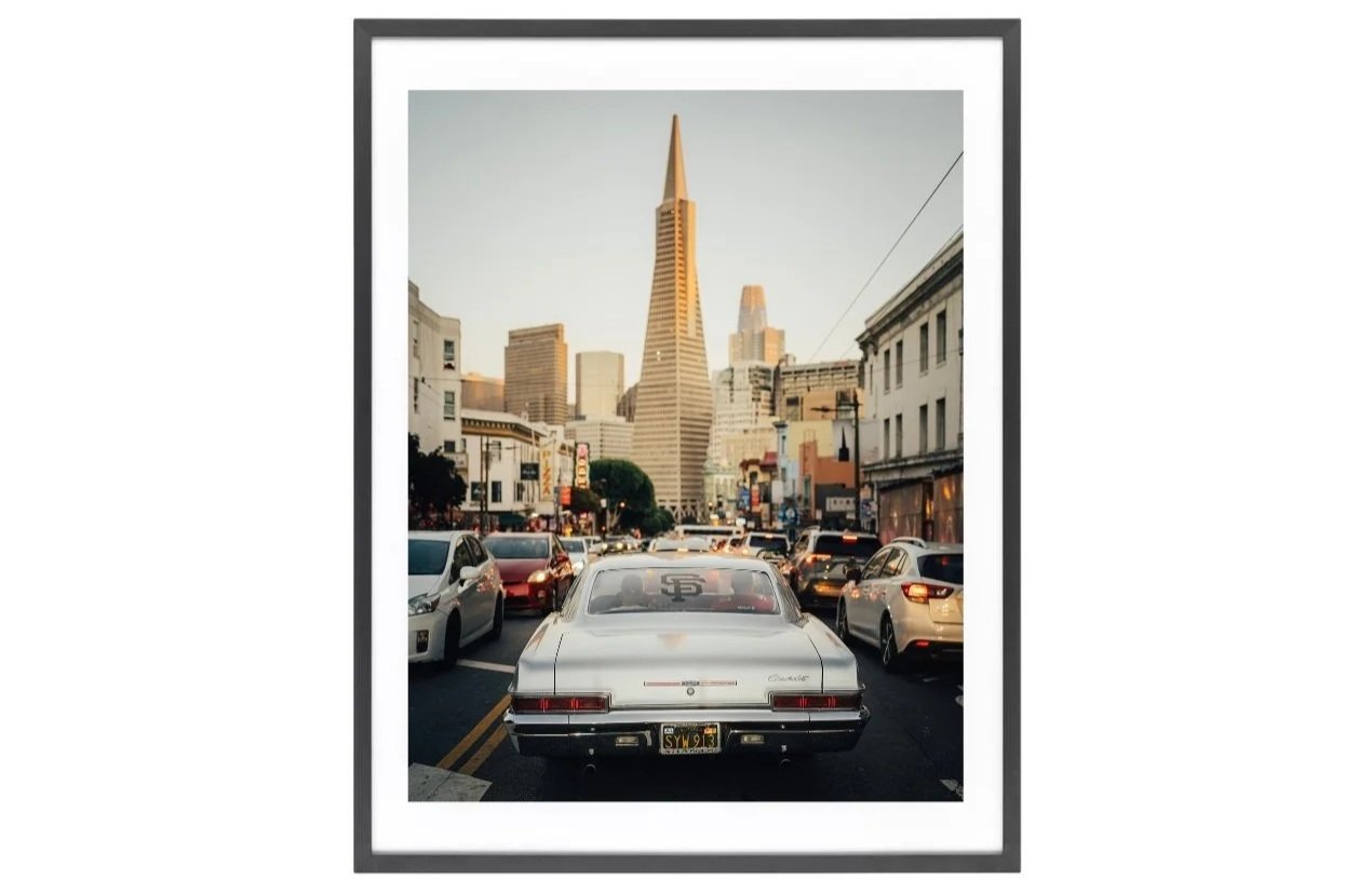Chevrolet Impala lowrider driving through San Francisco with the Transamerica Pyramid in the background