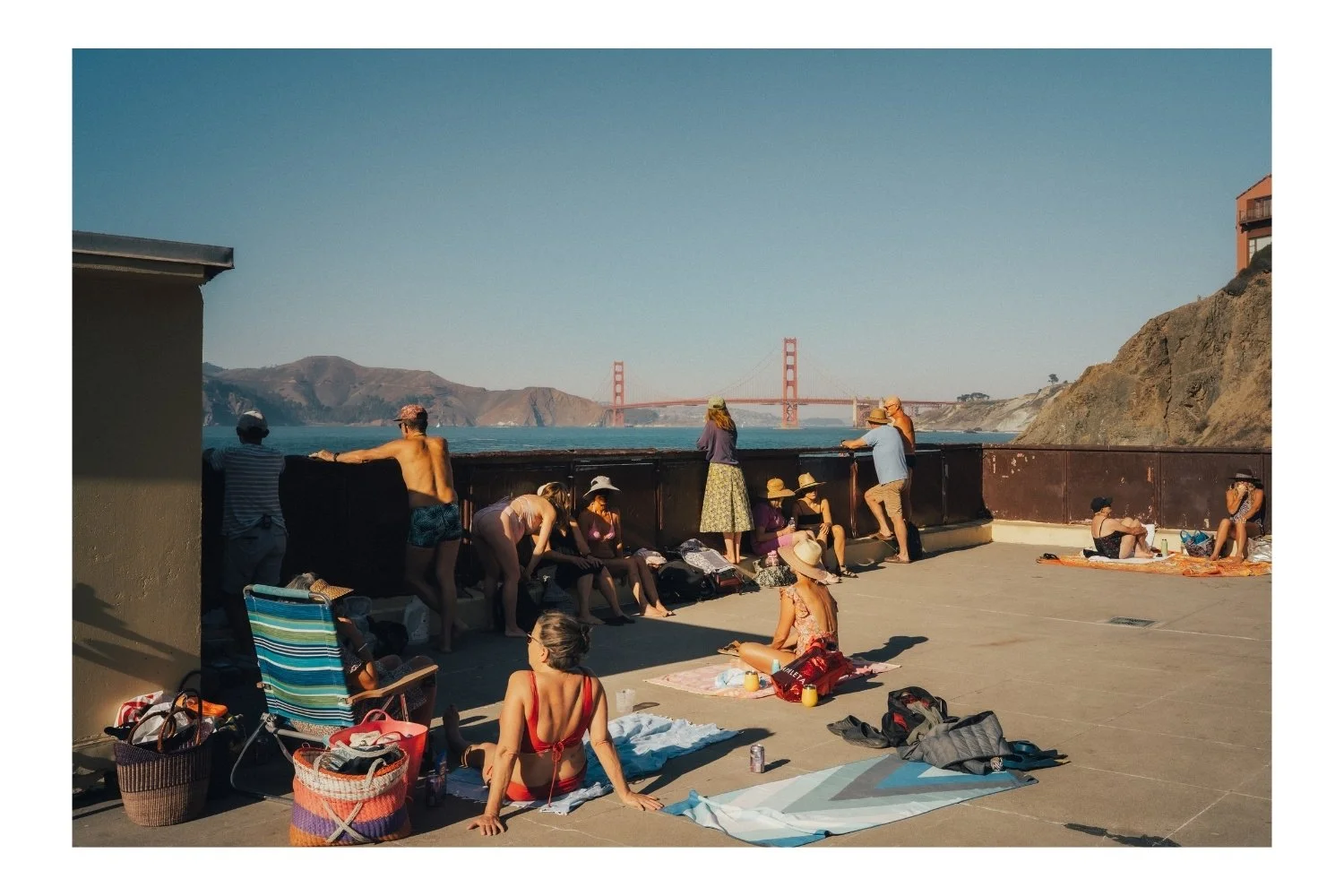 China Beach, people sun bathing, Golden Gate Bridge in the background. 