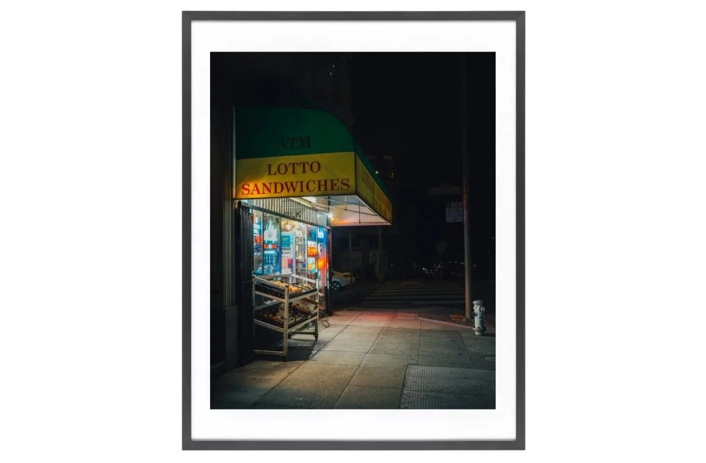 Night view of a grocery store on a North Beach street corner, glowing with colorful lights against the dark surroundings.
