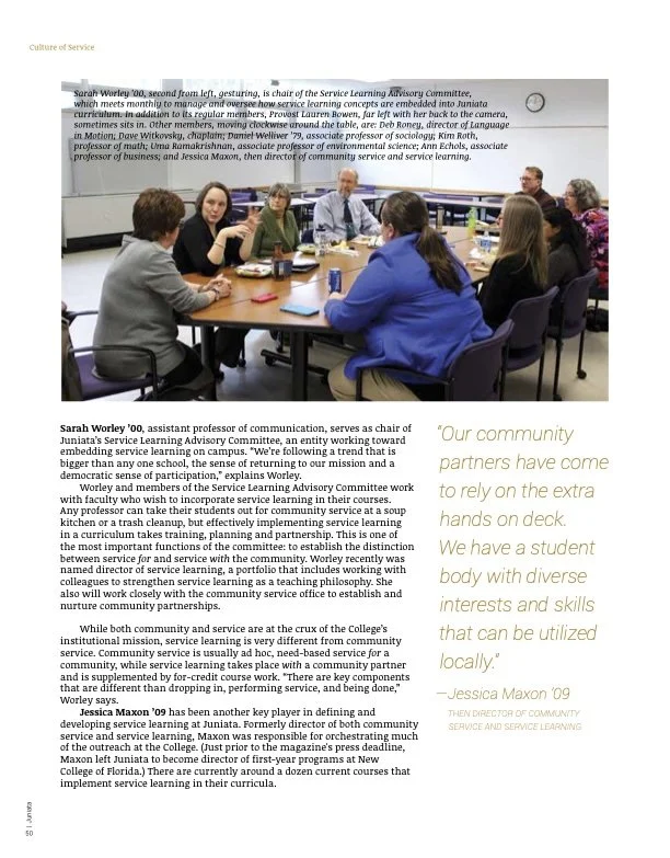 Group of people sitting around a rectangular table in a conference room, engaged in discussion, with a presentation screen in the background. Feature article news writing reporting creative writing.