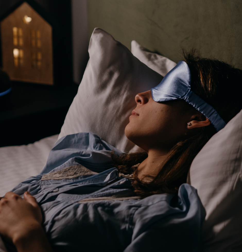 Woman sleeping in bed with a blindfold covering her eyes