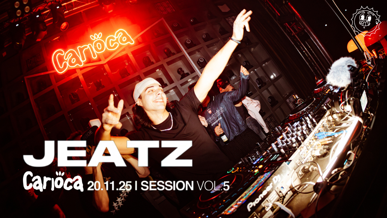 A DJ performs on stage with two people on either side, one reaching towards the DJ. The stage is illuminated with bright lights and geometric designs.