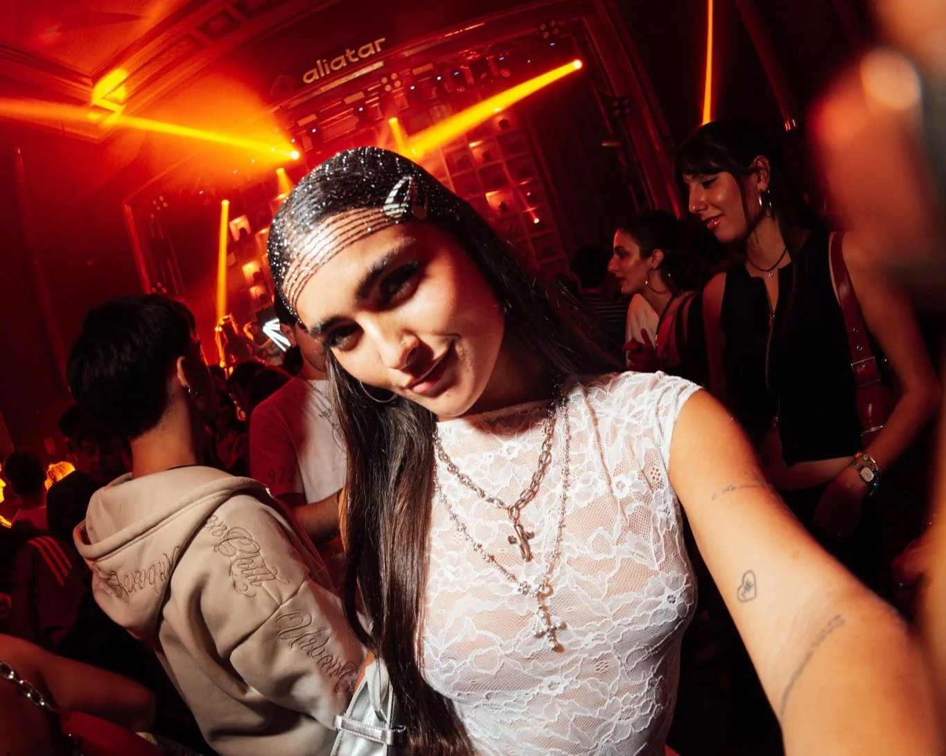 Group of young women dancing and enjoying themselves at a nightclub with colorful lighting.