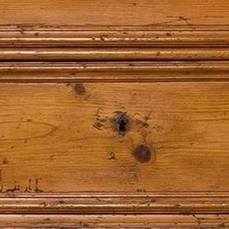 Close-up of a wooden surface with knots and grain patterns.