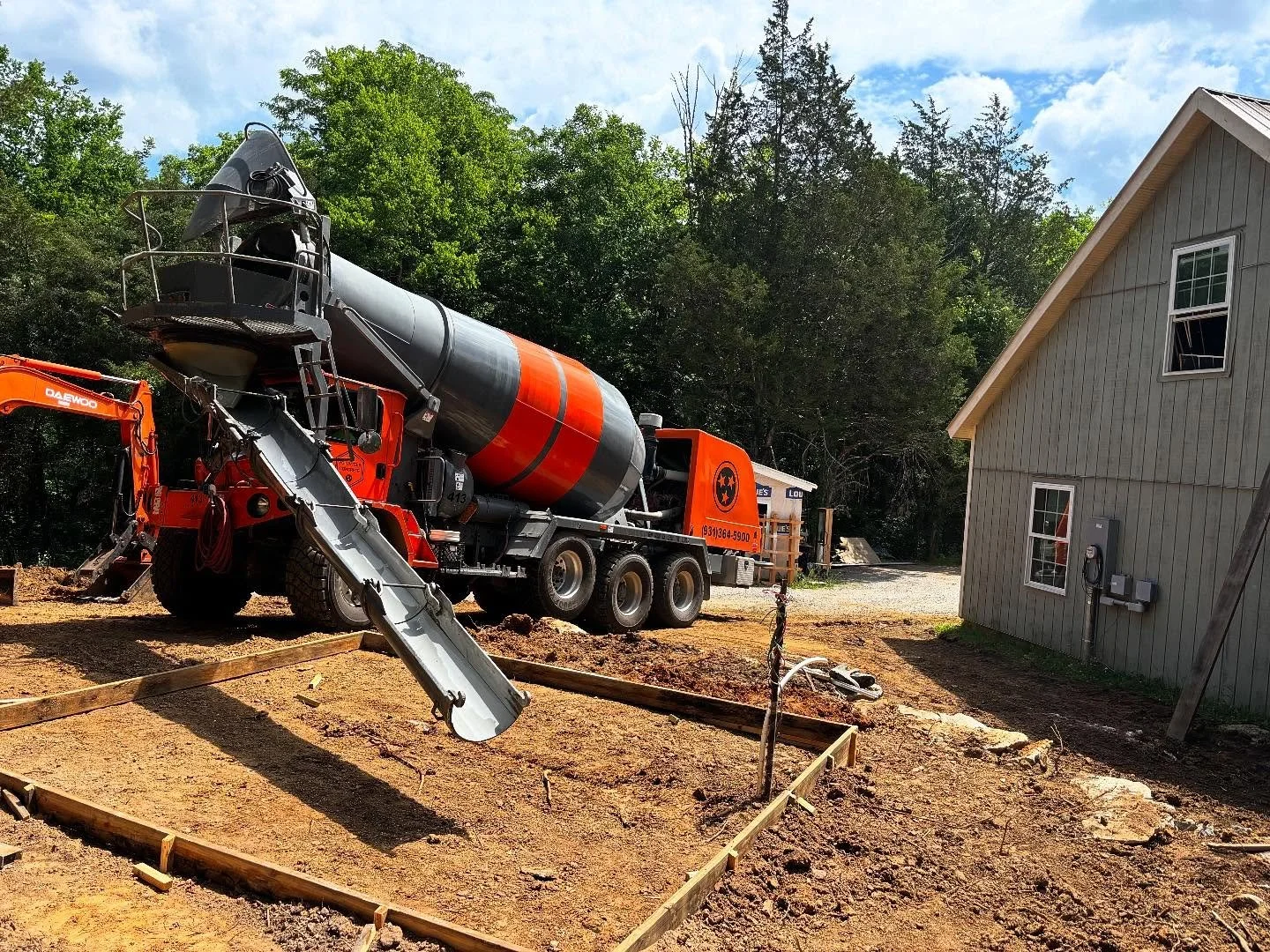 Fortunately, the concrete was poured for my dust collection and air compressor building on Tuesday before the rain. The driver of the truck drove right up the steep hill to the forms I put in.