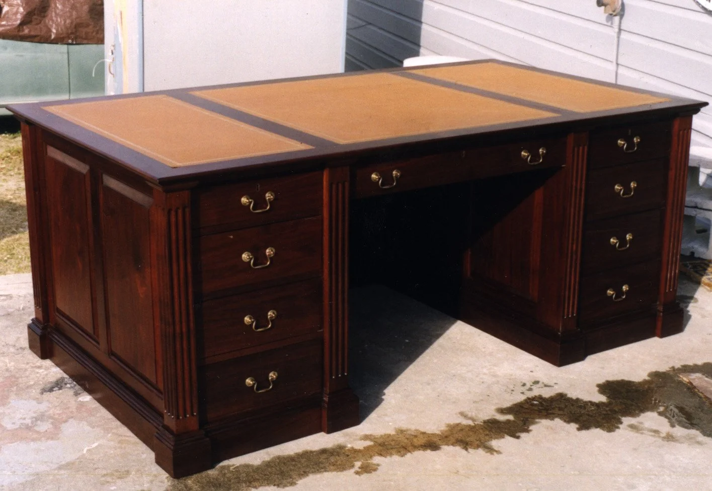 executive desk made from matched walnut and hand tooled leather top