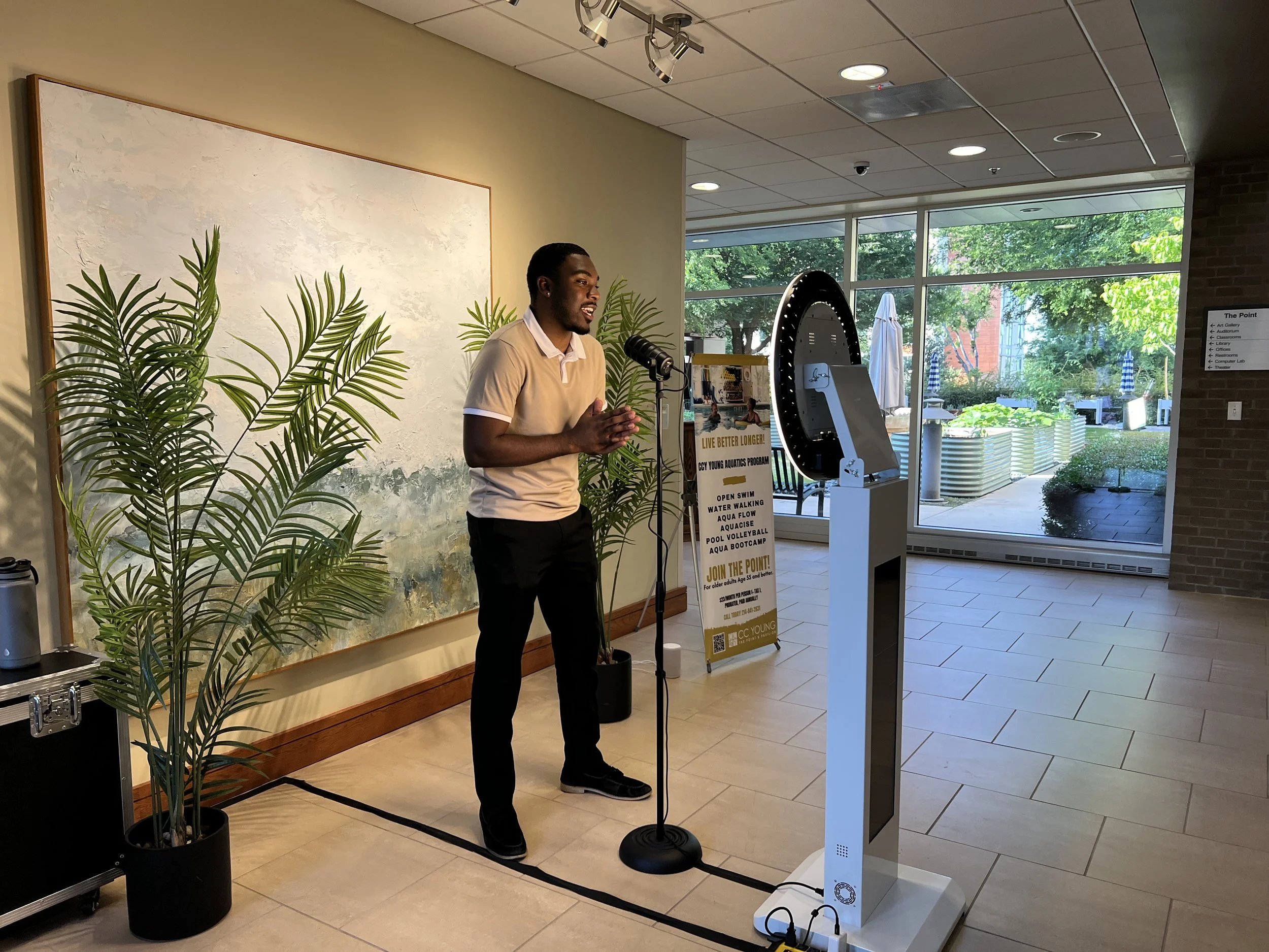 A man recording a message on video booth at anniversary party