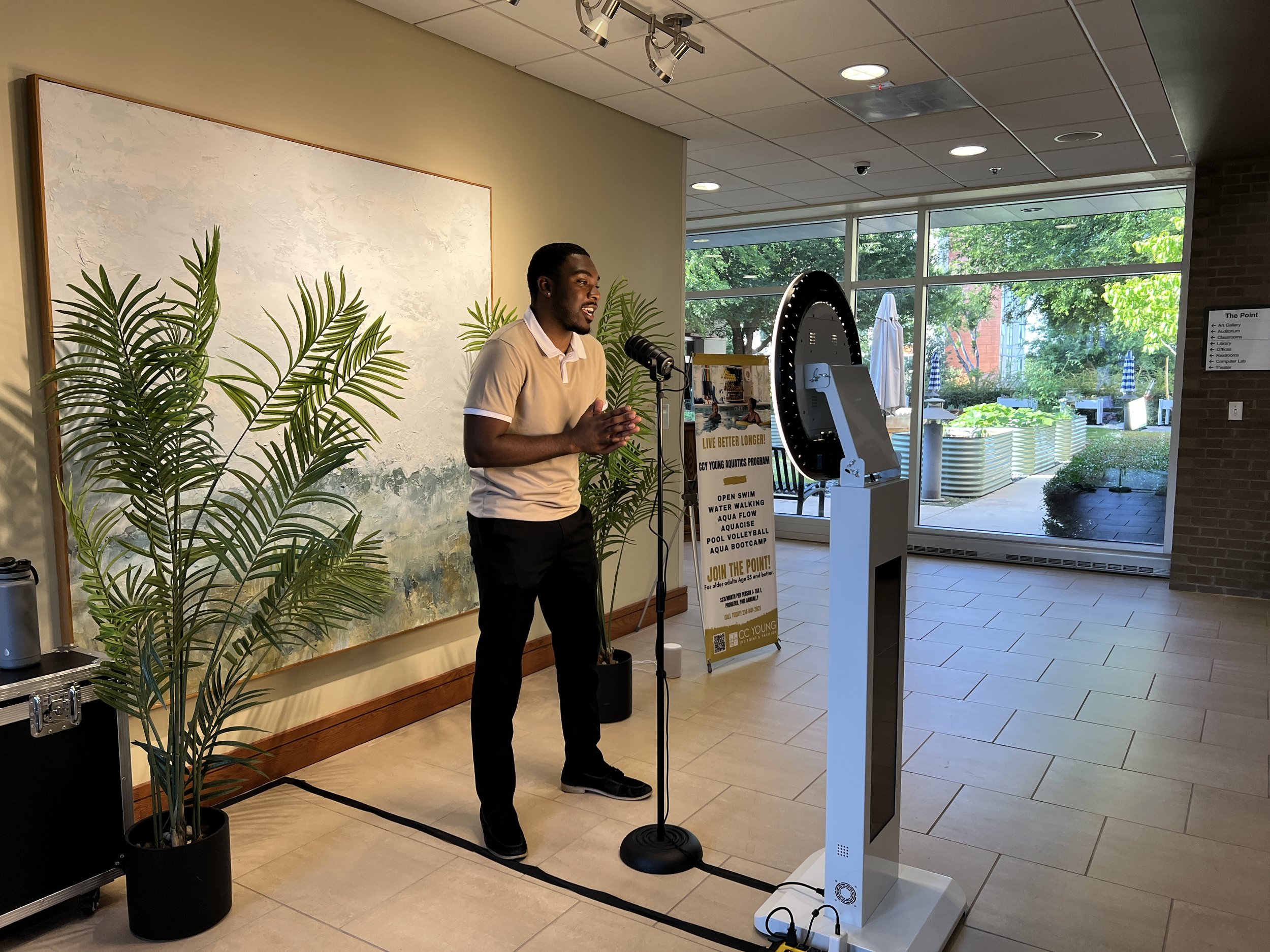 A man recording a message on video booth at anniversary party
