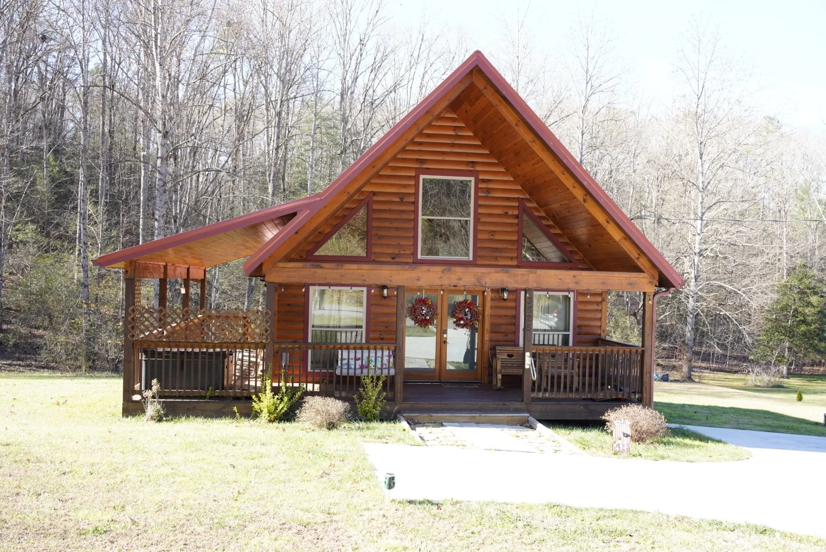 A cozy bar with a marble-topped counter, wooden bar stools, and a large window letting in natural light. The wall behind the bar has shelves with bottles and glassware, and the room has patterned wallpaper and warm lighting fixtures.