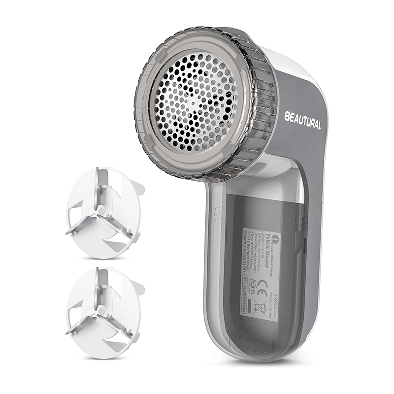 A white and gray electric fabric shaver with two replacement foil heads.