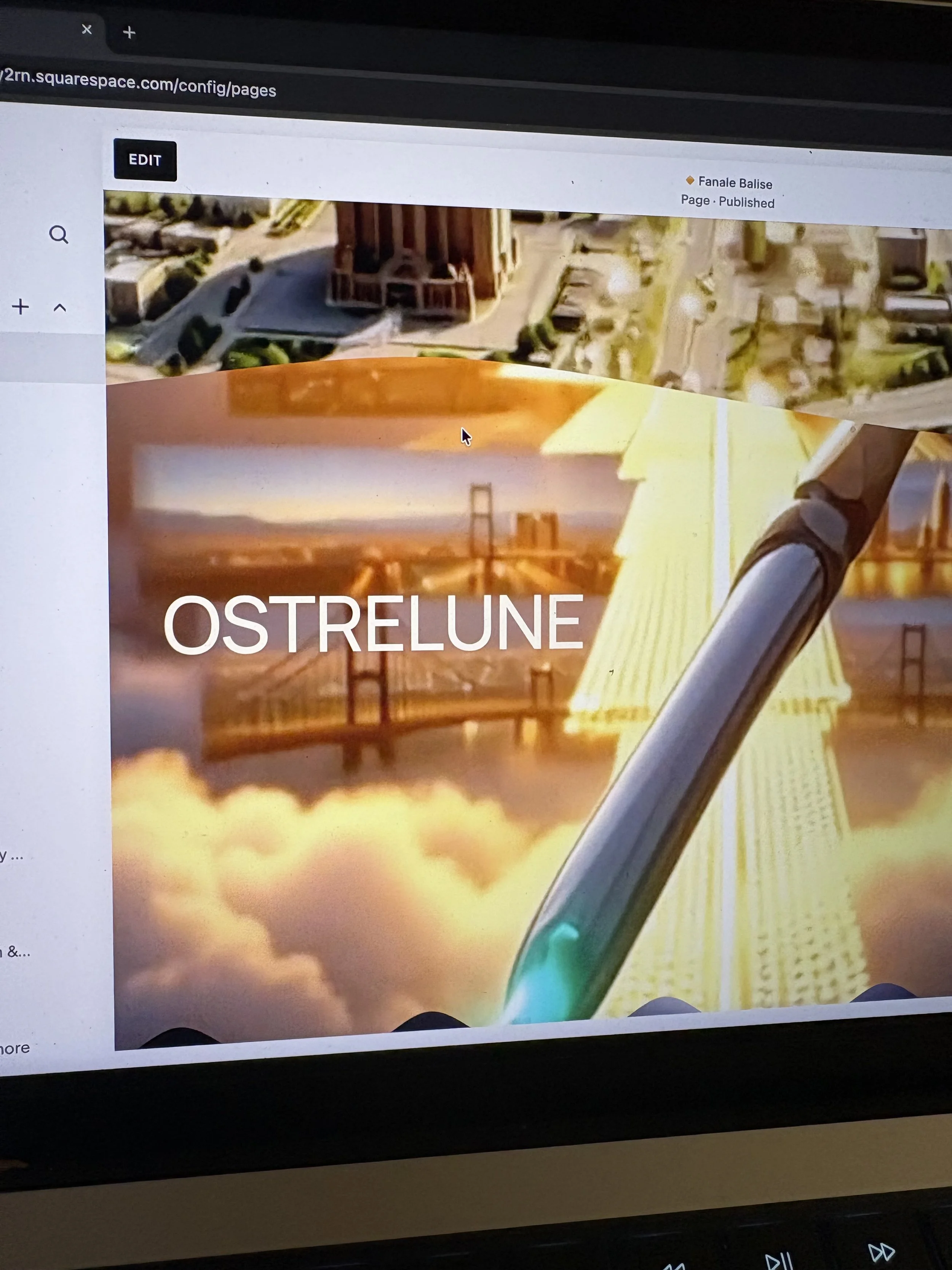 A computer screen displays a website with a cover photo of a bridge, possibly the Golden Gate Bridge, below a view of a cityscape with buildings and streets.
